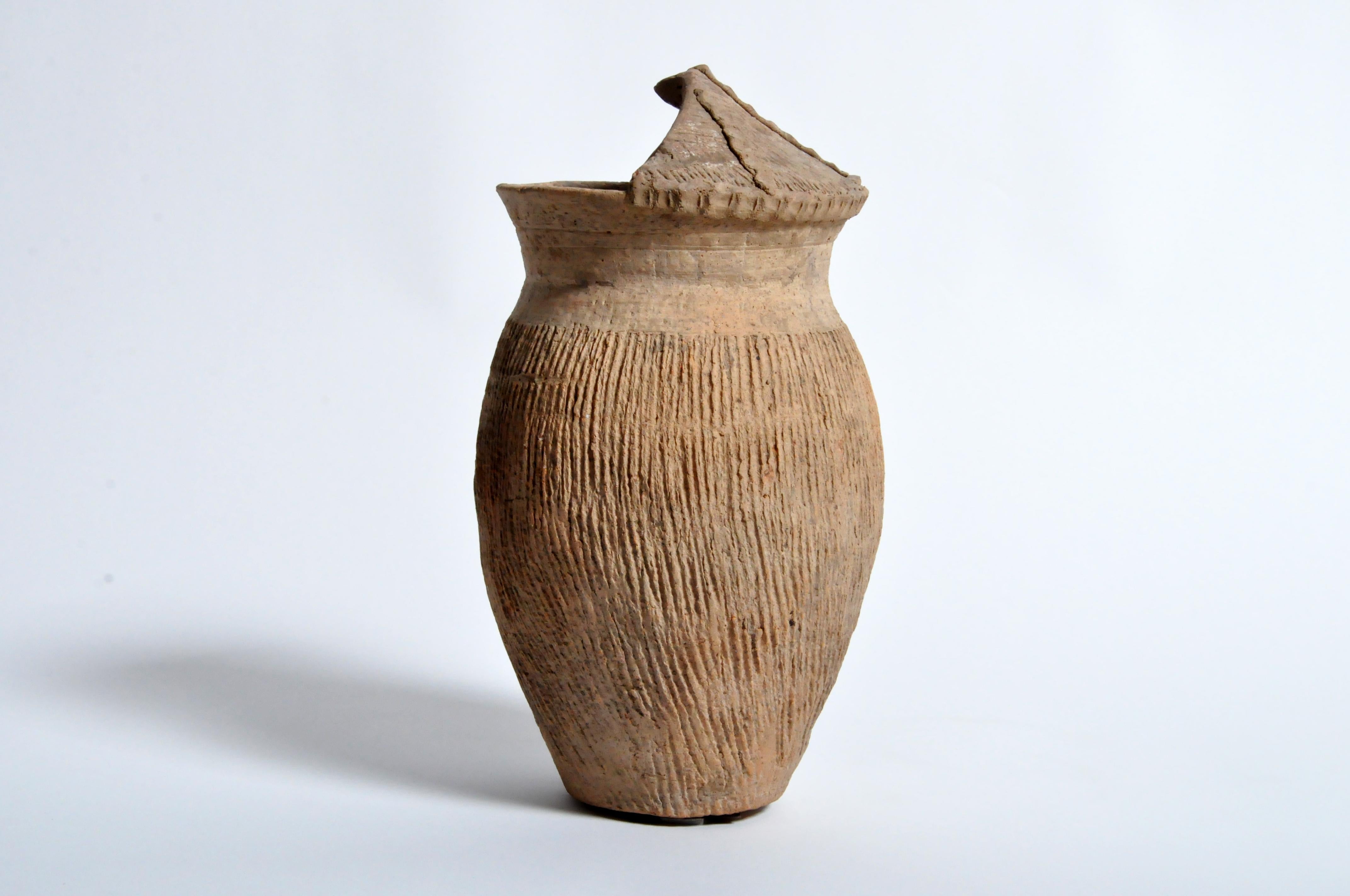 Northern China has a settled history that goes back more than 5,000 years. All along the western reaches of the Yellow River settlements sprung up and some of the first evidence we have is in the form of pottery. This terra cotta vessel was buried