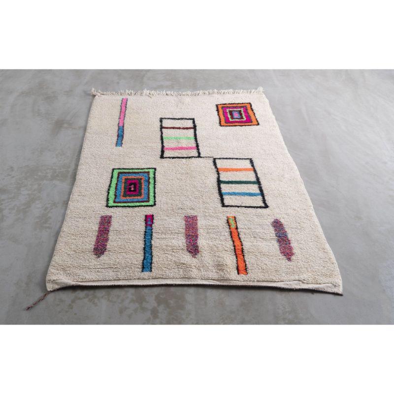 The neon pink, green, orange and blue cubist motifs against the creamy white wool give this Moroccan hand-woven rug add a fun touch to this gentle work of fabric, a timeless example of the simple appeal of woven linen, perfect for a living room,