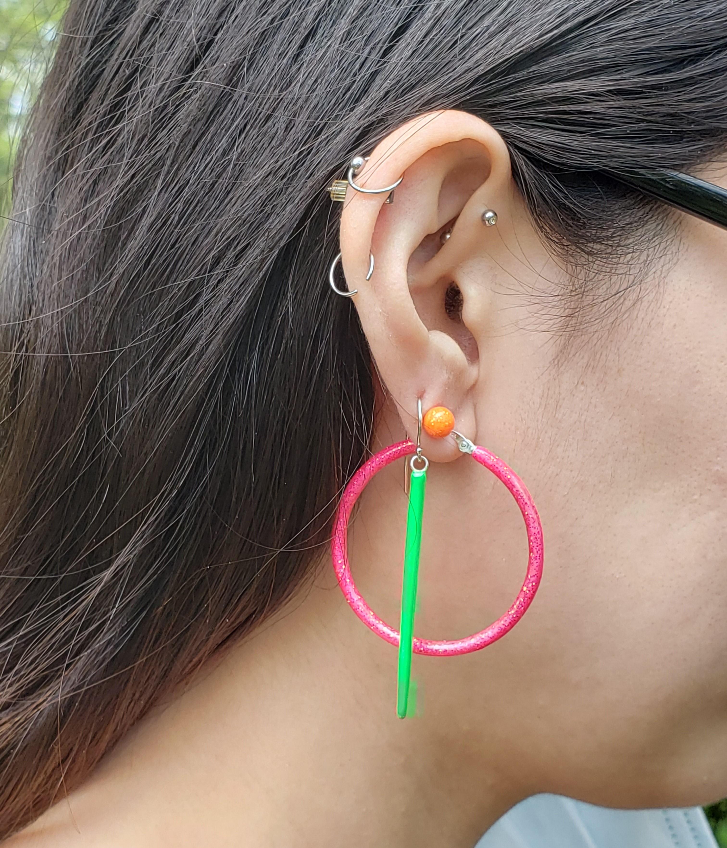 Edgy Neon Green Enamel Sterling Silver Spike earring handmade with a diamond set in a bagel setting to dangle off the spike. The Earring is in complete motion since the Spike is linked into the dangle diamond and then attached to a eurowire.
The