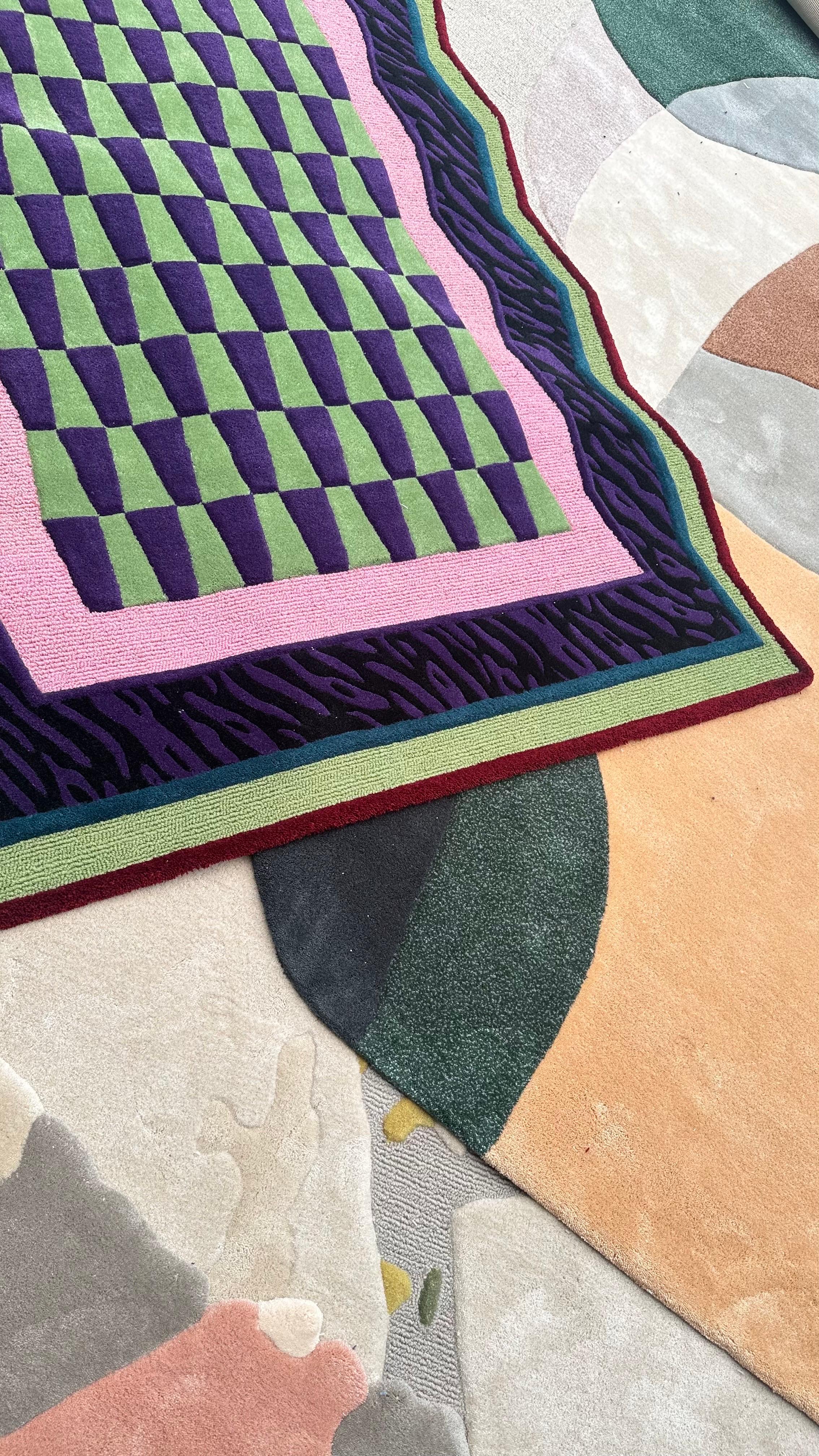 Il tappeto Neon Grid Mosaic è un'audace fusione di accenti di colore ispirati agli anni '90 e di un dinamico motivo a mosaico. Il design a scacchiera in verde lime e viola intenso crea un effetto ottico sorprendente, mentre il bordo frastagliato in