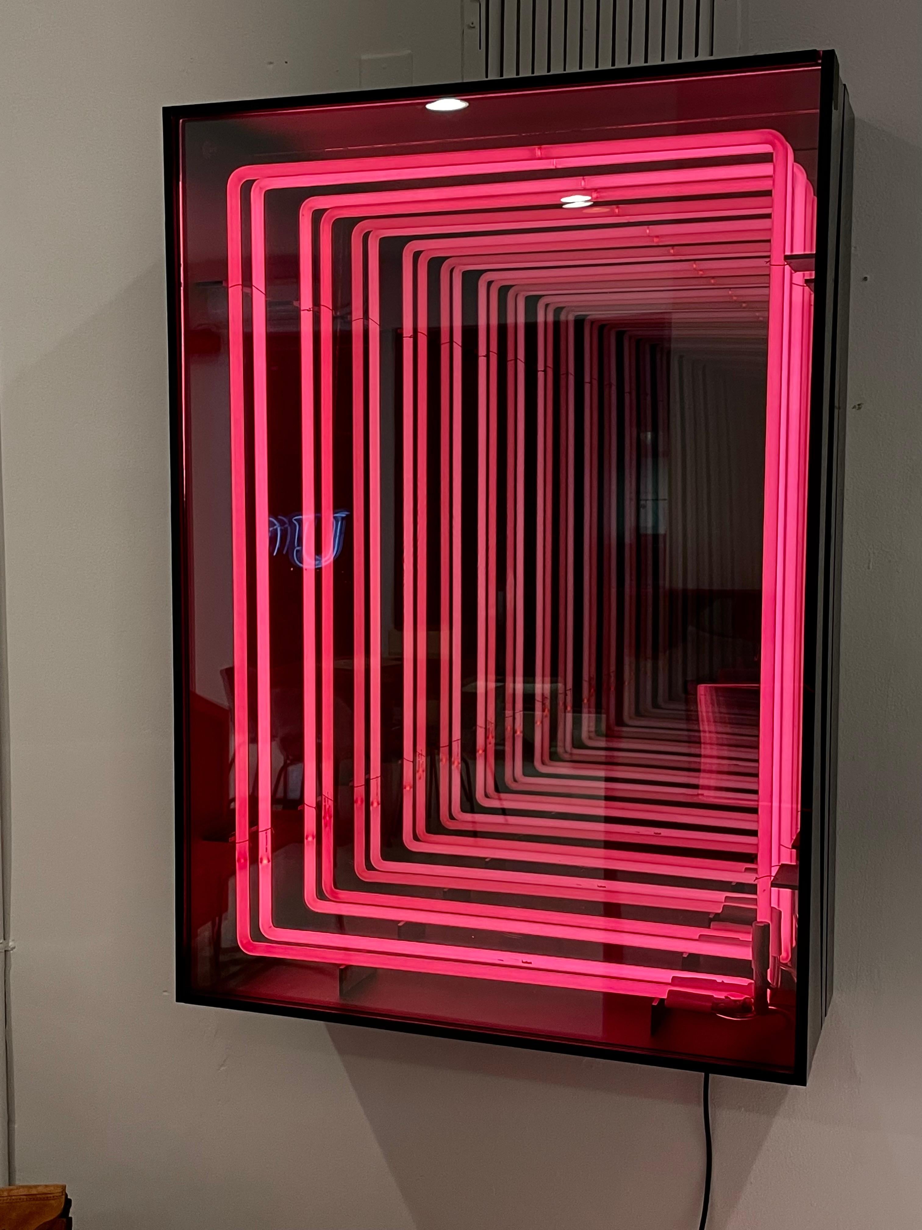 Stunning neon and plexiglass infinity mirror by Merit. Handmade in Los Angeles. Incredible presence with two neon rings that reflect deep into the mirror. Great illusion. All encased in black plexiglass. Looks great during the day and even better in
