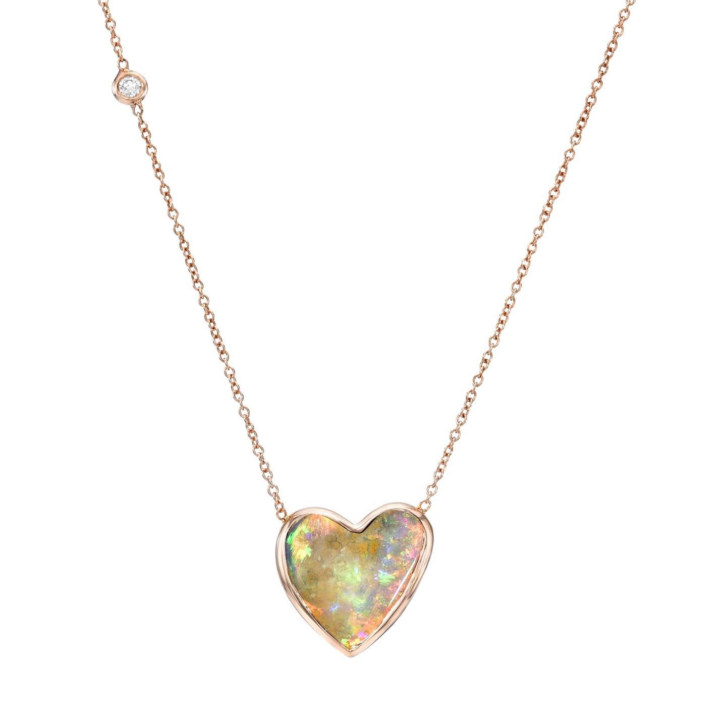 An opal heart charged with color, flashes from this Australian Opal Necklace. Gleaming from within its bezel setting, the Crystal Opal flaunts electric pinks, greens and blues. From behind the opal glows a rose gold plate with a heart-shaped cutout