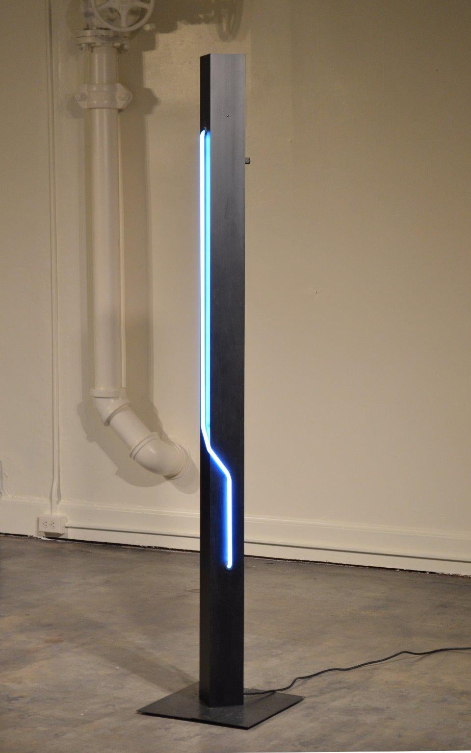 Post-Modern sculptural blue neon light with dimmable torchiere. Designed by Dan Chelsea / Let There Be Neon, Inc. (Rudi Stern) for George Kovacs Lighting, 1983.

The central column is 4