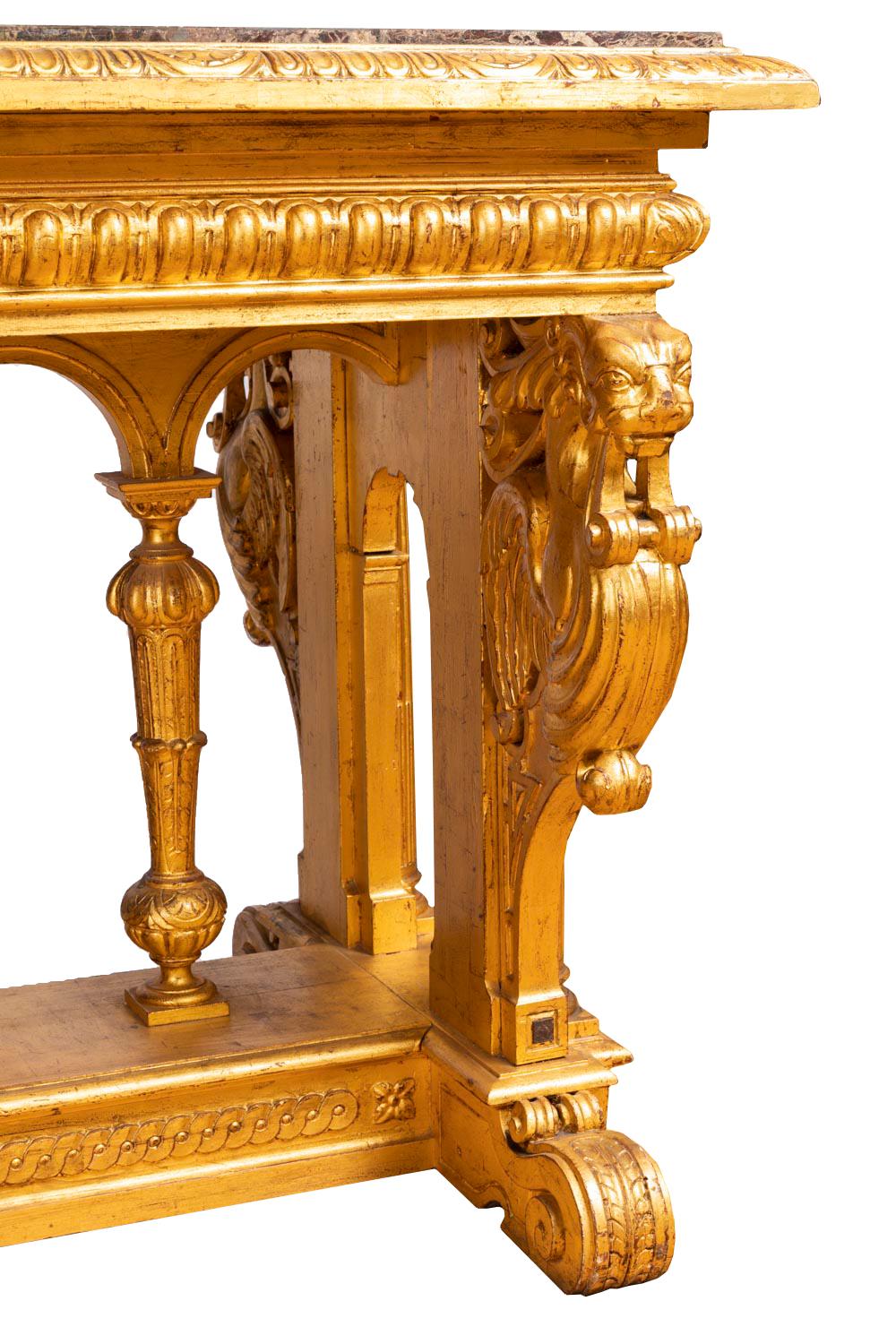 Renaissance style table in giltwood standing on four short small feet in shape of flattened foliage scrolls. Stand in the style of Roman cartibulum, in French called “fan” table because of the shape of the stand. A crossing adorned with interlaces