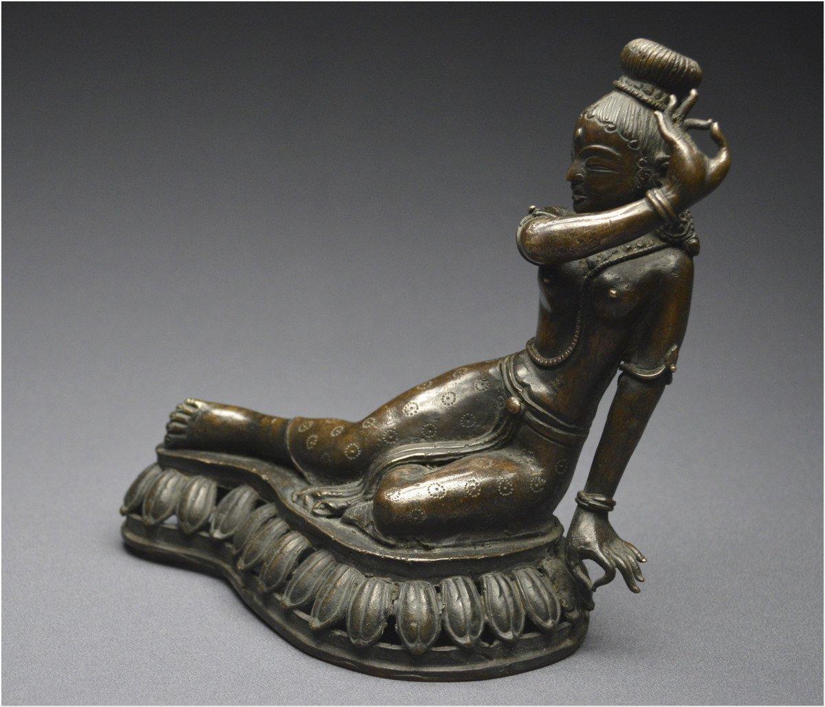 Representation in copper alloy of a Deva with her hands in an argument position

Nepal
19th century

The goddess is represented with her legs stretched out on a base decorated with openwork lotus leaves, the bust straight, bare. The left arm