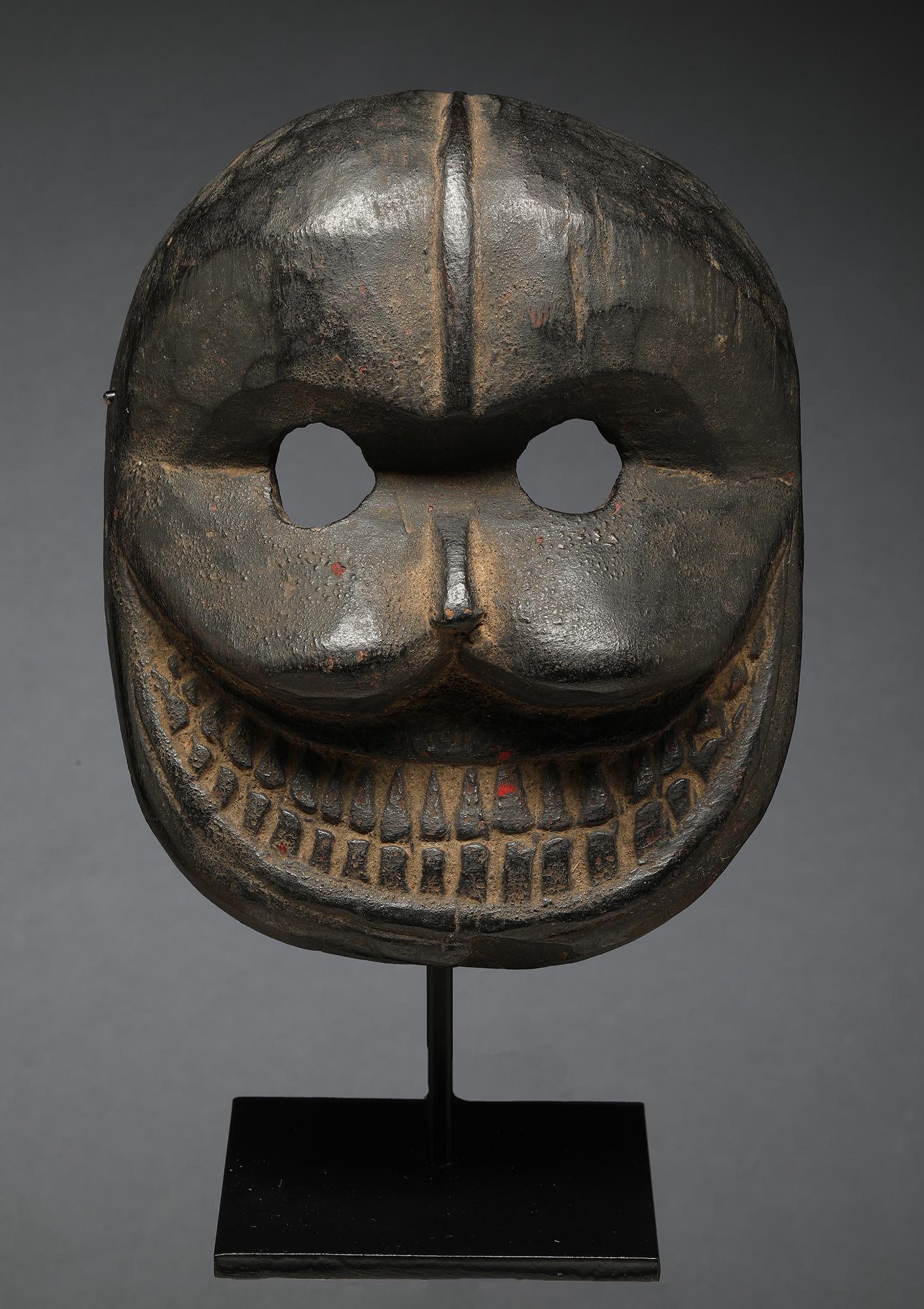 Masque de danse ovale en bois du Népal avec une expression puissante, des yeux ouverts et une bouche ovale avec des dents finement sculptées.  Pommettes saillantes et lourdes. Ce masque représente le bouddhiste tibétain et népalais Citipati, le