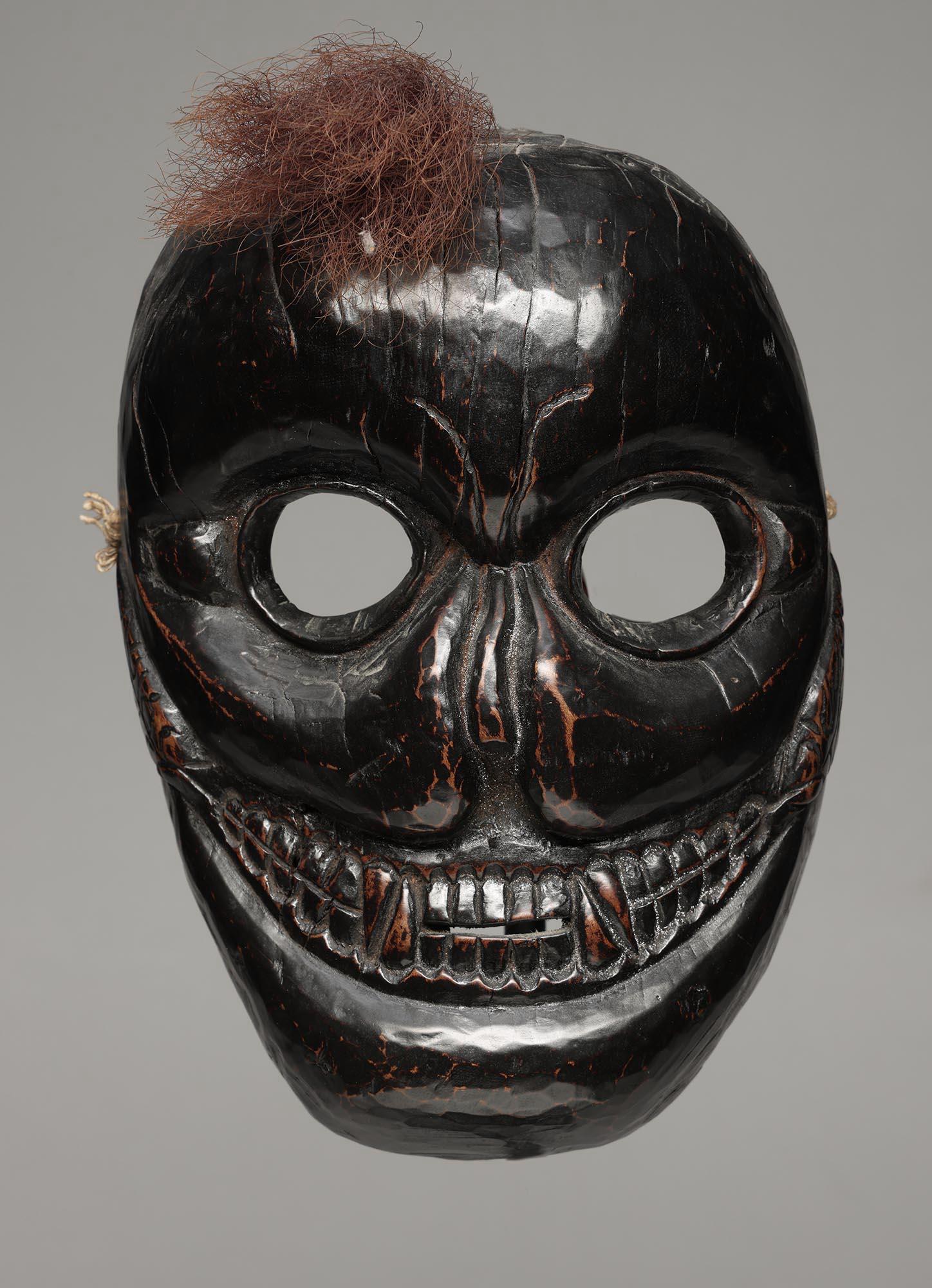 Masque de danse ovale du Népal avec une expression puissante, des yeux ouverts et une bouche ovale avec des dents finement sculptées, des oreilles joliment sculptées représentant le Citipati bouddhiste, le protecteur à tête de mort. Forte patine