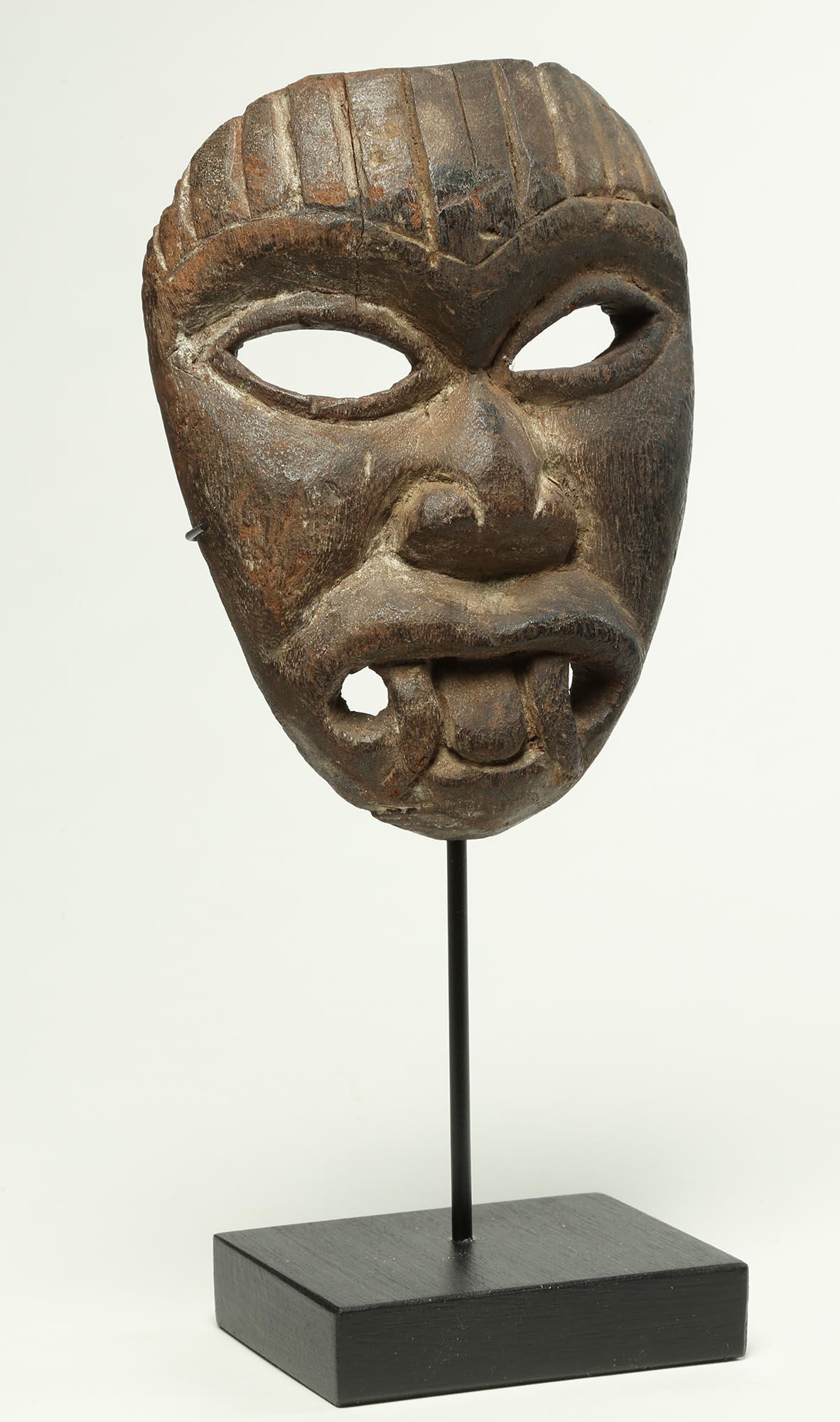 An intense demon-chaser mask from Nepal, Northern India or other Himalayan culture. Carved wood, early 20th century. Open mouth with fangs, wild asymmetrical eyes and detailed hair. Depicts a protective demon-like visage thought to repel malevolent