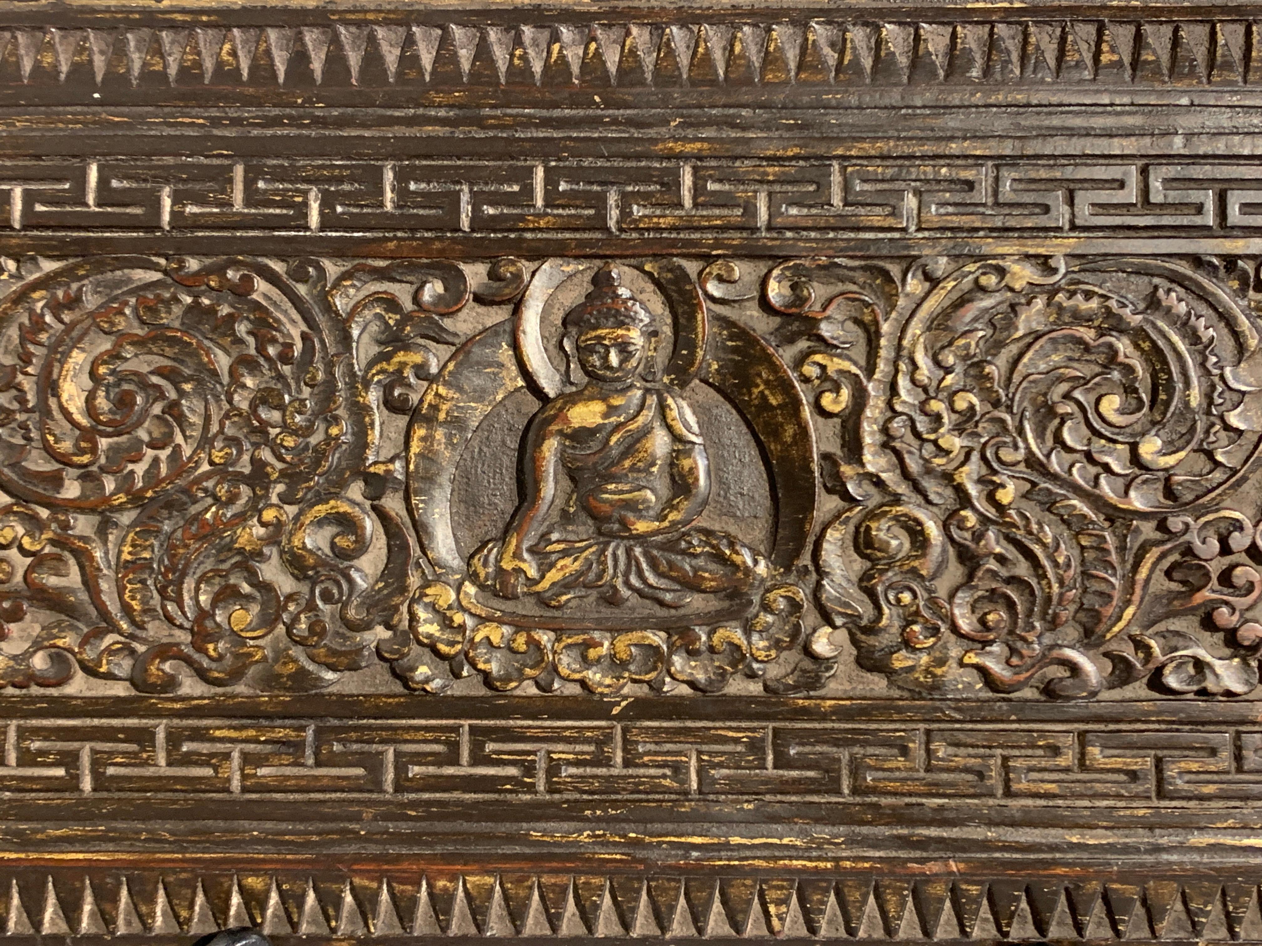 Ein schöner und ungewöhnlicher hölzerner Buch- oder Manuskripteinband mit geschnitzter Außenseite und bemalter Innenseite, 15. Jahrhundert, Nepal. 

Das Äußere des Manuskriptdeckels ist üppig geschnitzt mit einer Figur von Shakyamuni, dem