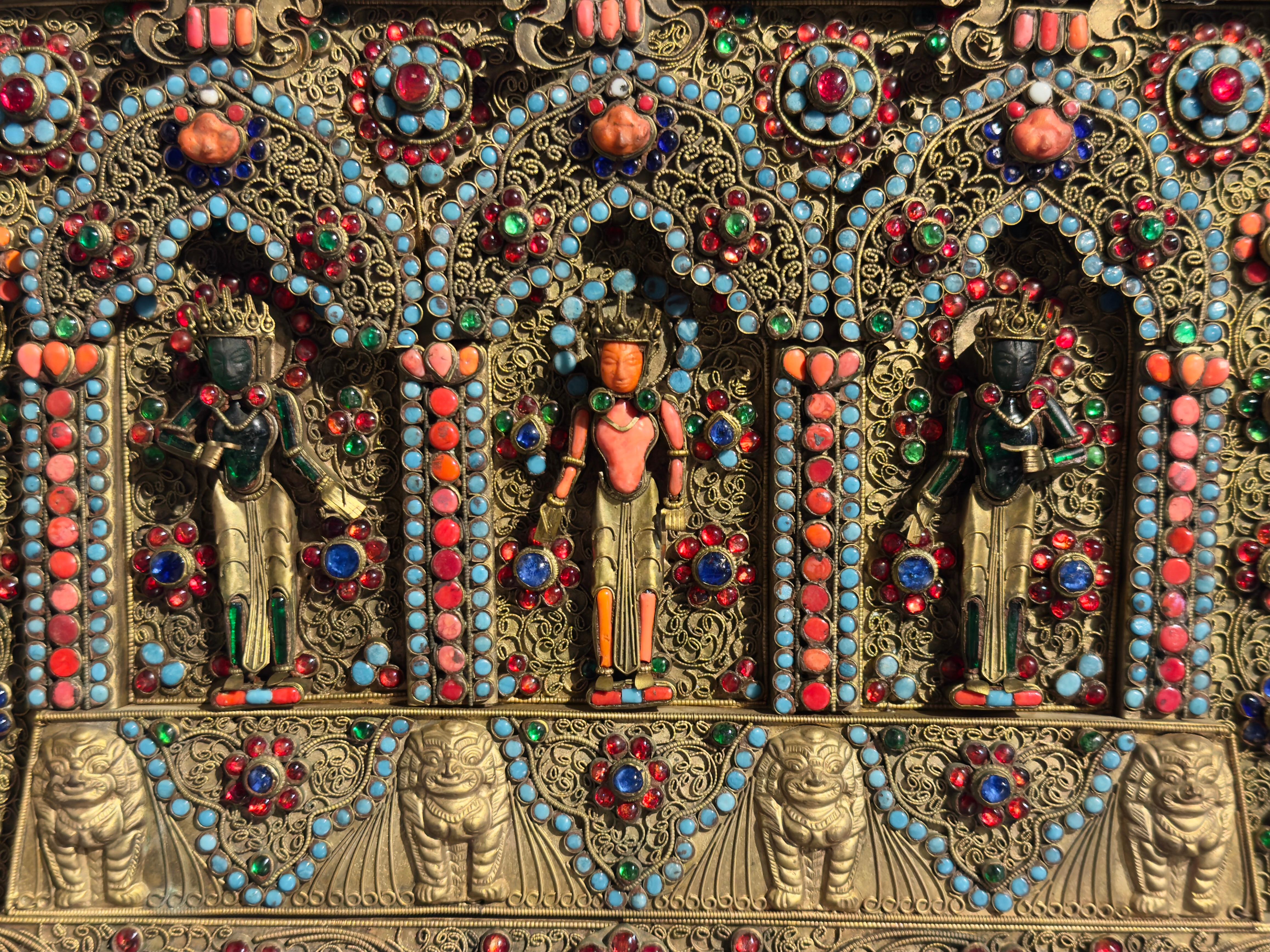 A fine and impressive Nepalese gilt copper filigree votive plaque inset with coral, turquoise, and colored glass 