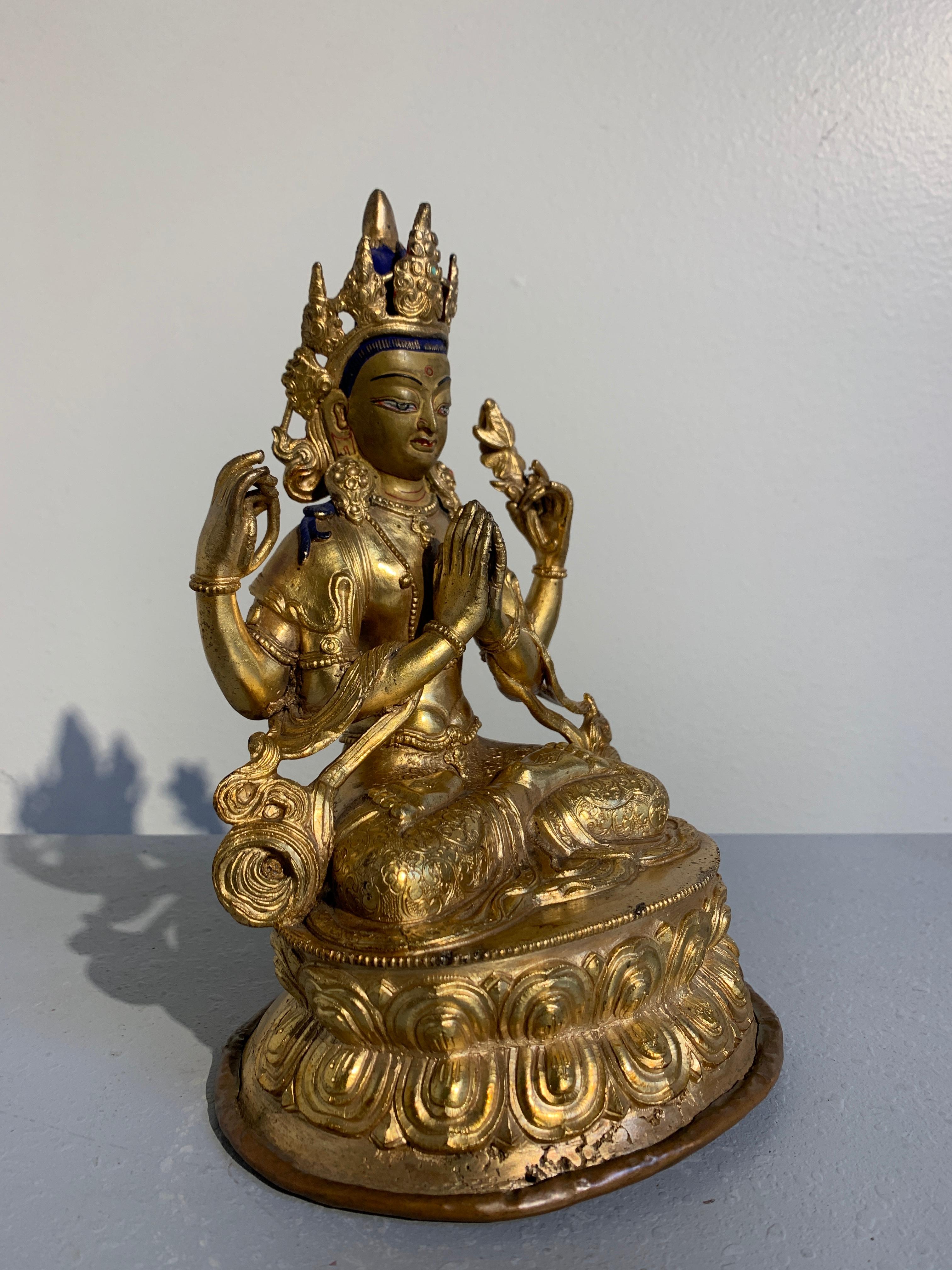 A nice vintage early to mid-20th century gilt bronze sculpture of the Buddhist deity Avalokiteshvara in his four armed form, known as Chaturbuhja, or Chenrezig in Tibet.

Chenrezig, a form of Avalokiteshvara, the bodhisattva of compassion (known