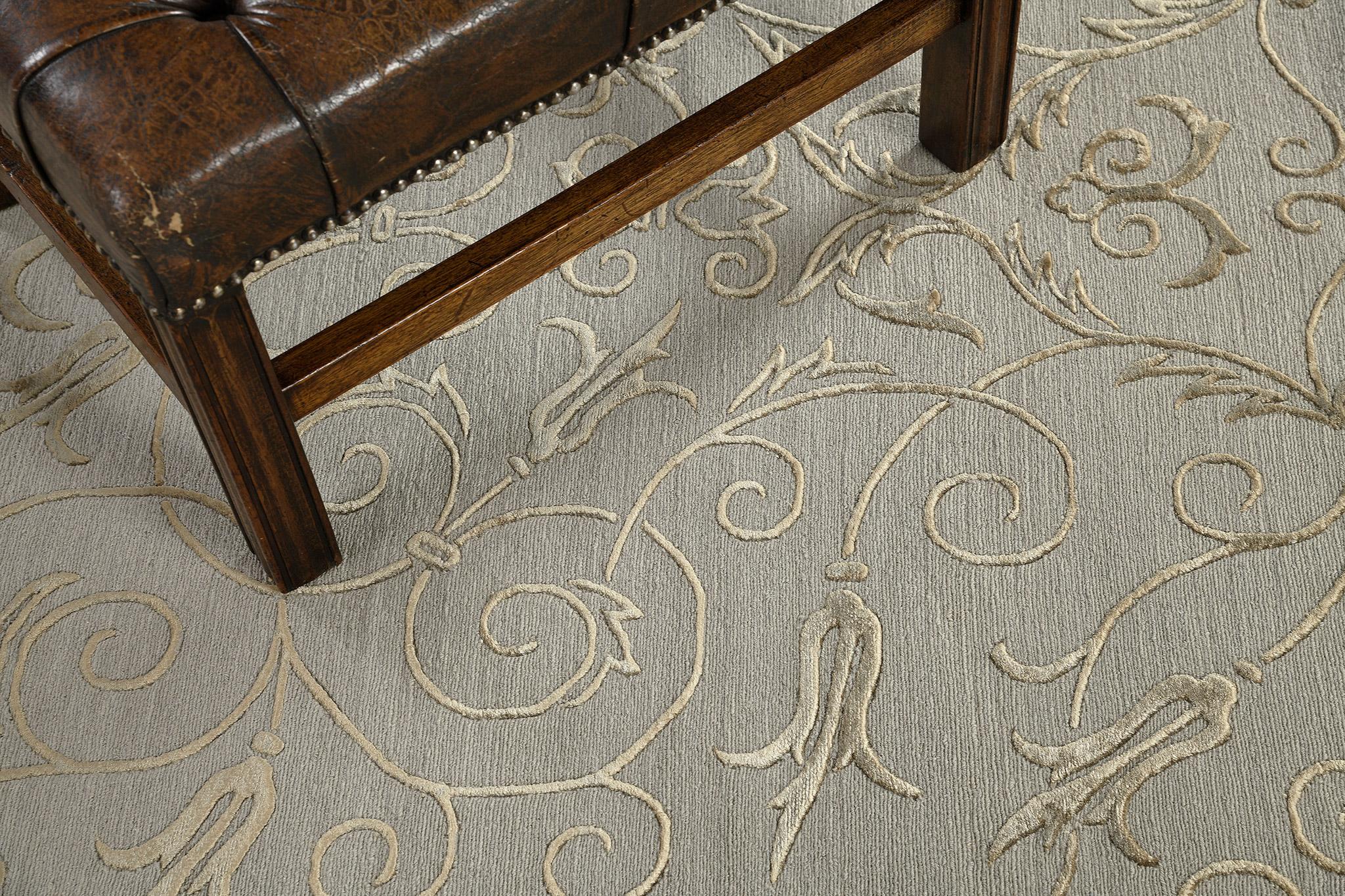 This magnificent Nepalese Modern Rug encompasses an elegant and sophisticated pattern. This masterpiece is aligned with each other in that these golden spirals and vines are perfectly matched over in a gray field. A home decor that puts on your