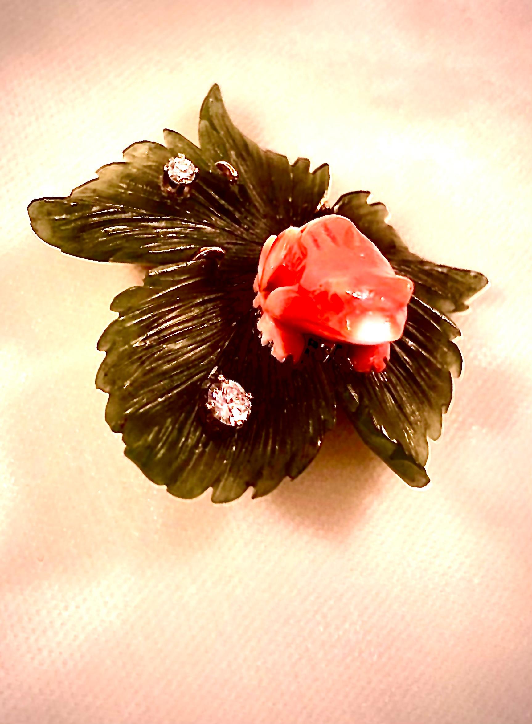 Exquisite naturalistic hardstone brooch. An orange/red coral frog is shown perched upon an intricately and realistically carved nephrite jade leaf.

The leaf is adorned with two brilliant white substantial diamonds representing water droplets. The
