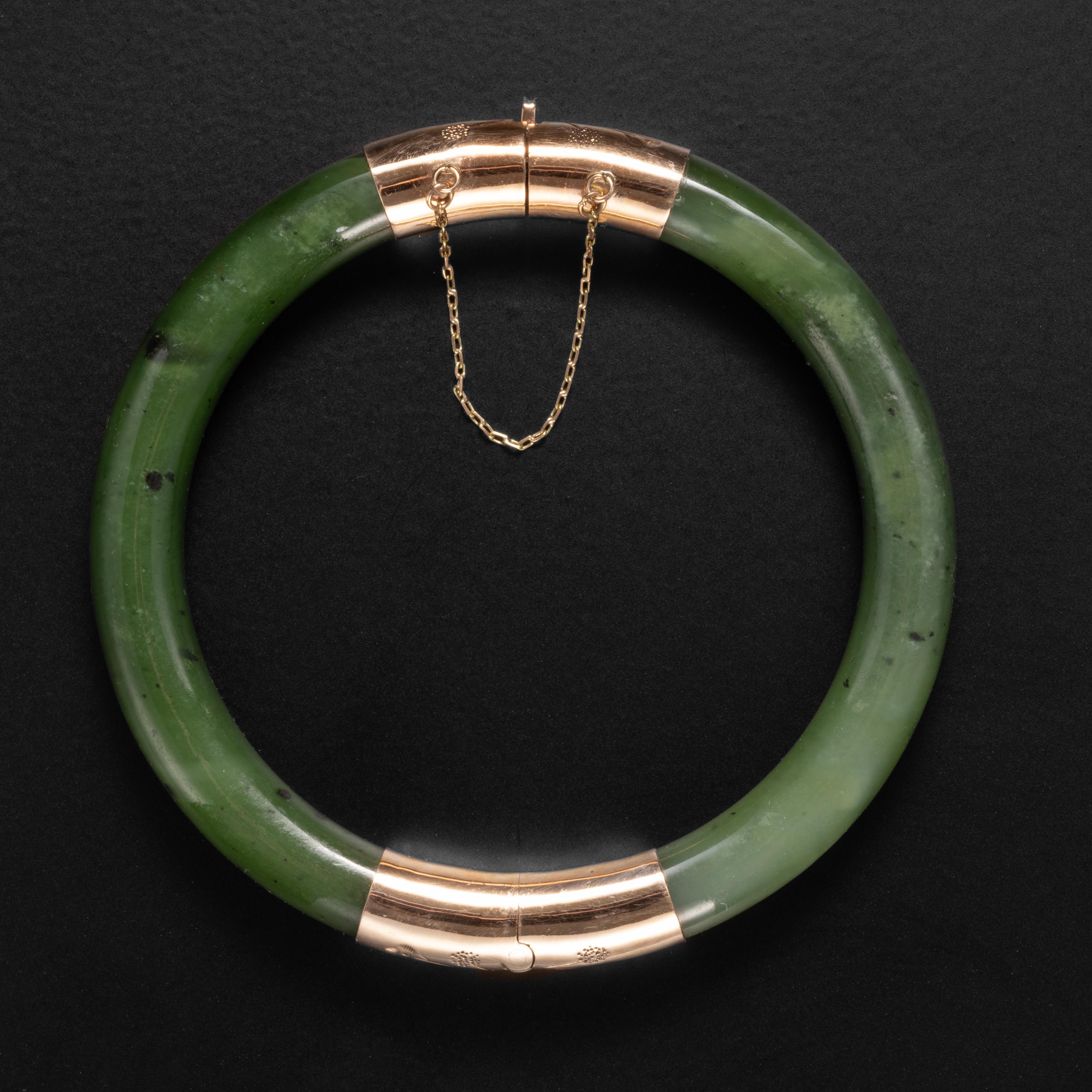 This highly translucent nephrite jade bangle almost looks like it could be made of glass. But it's not; it's nephrite jade: the toughest gem in the world. The inner diameter is 59mm, but the etched 14K gold hinge opens the bangle up to accept a wide