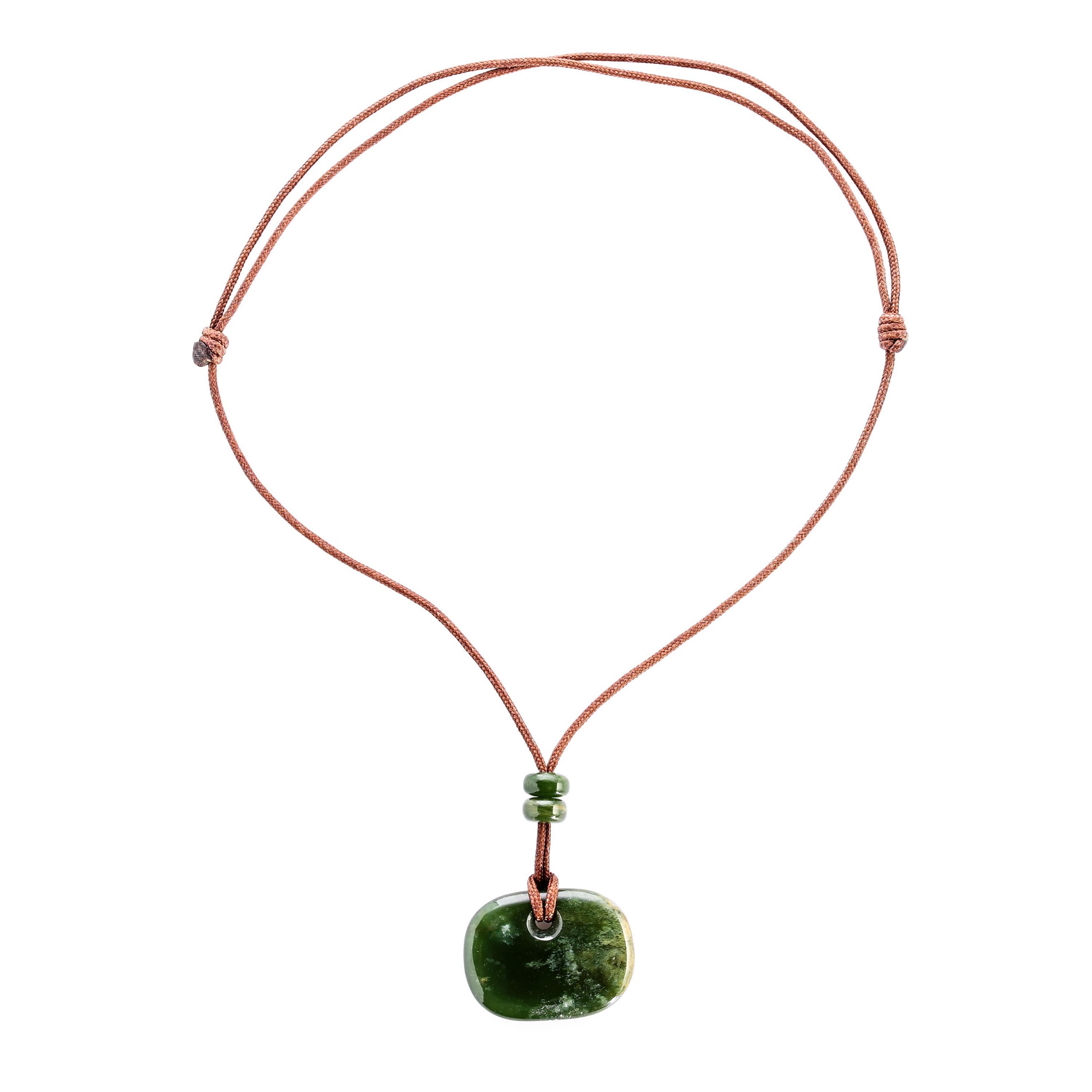Hand-carved by a young lapidary artist on the West Coast of the United States, this unusual and beautiful oval nephrite pendant features a high-gloss polish that and displays two different faces, depending upon which way you wear it. On one side,