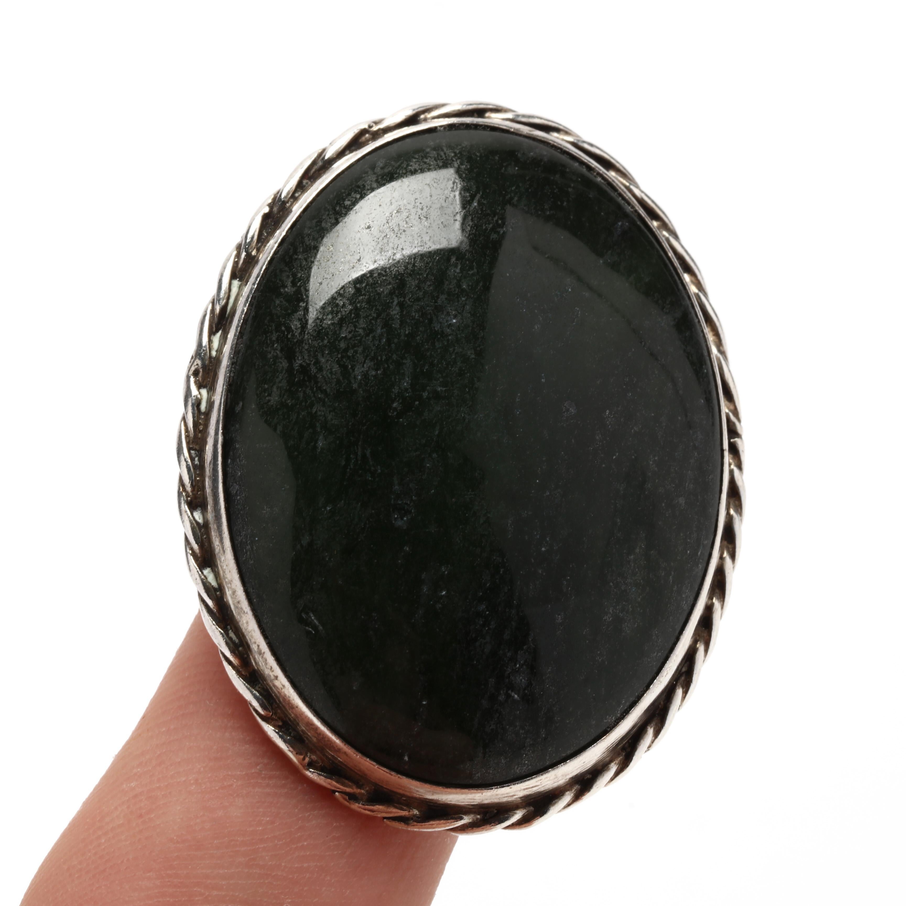 Ce magnifique pendentif ovale en jade néphrite est fabriqué à la main en argent sterling et constitue l'ajout parfait à toute collection de bijoux. Fabriqué en jade néphrite naturel, ce pendentif mesure 1,75 pouce de long et est poli pour obtenir