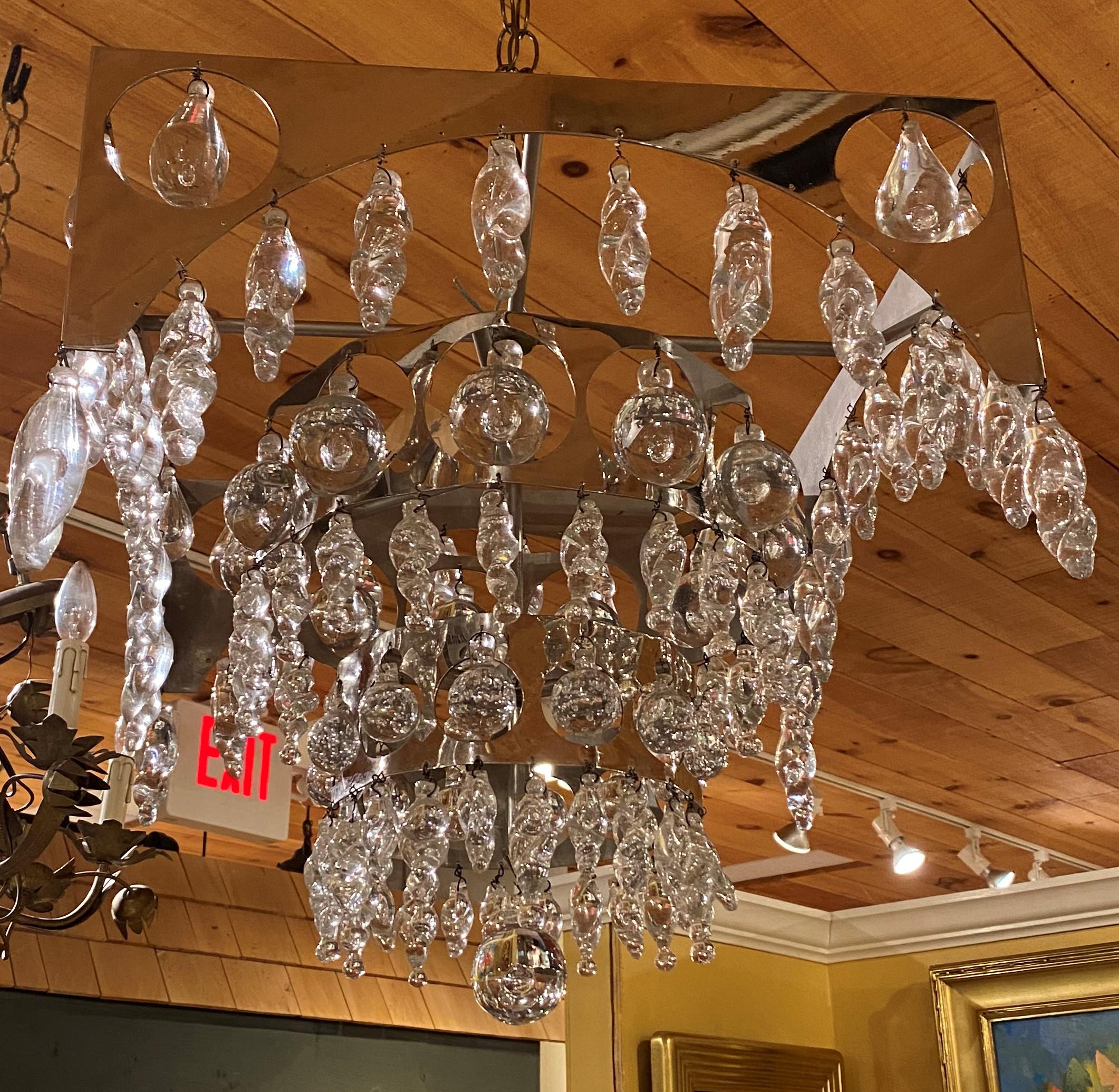 A fine mid-20th century designer chrome and crystal three-tier chandelier by Nepir Portugal in the Art Deco style with square top tier and two graduated round lower tiers, each adorned with solid round bubble glass pendants, as well as smaller