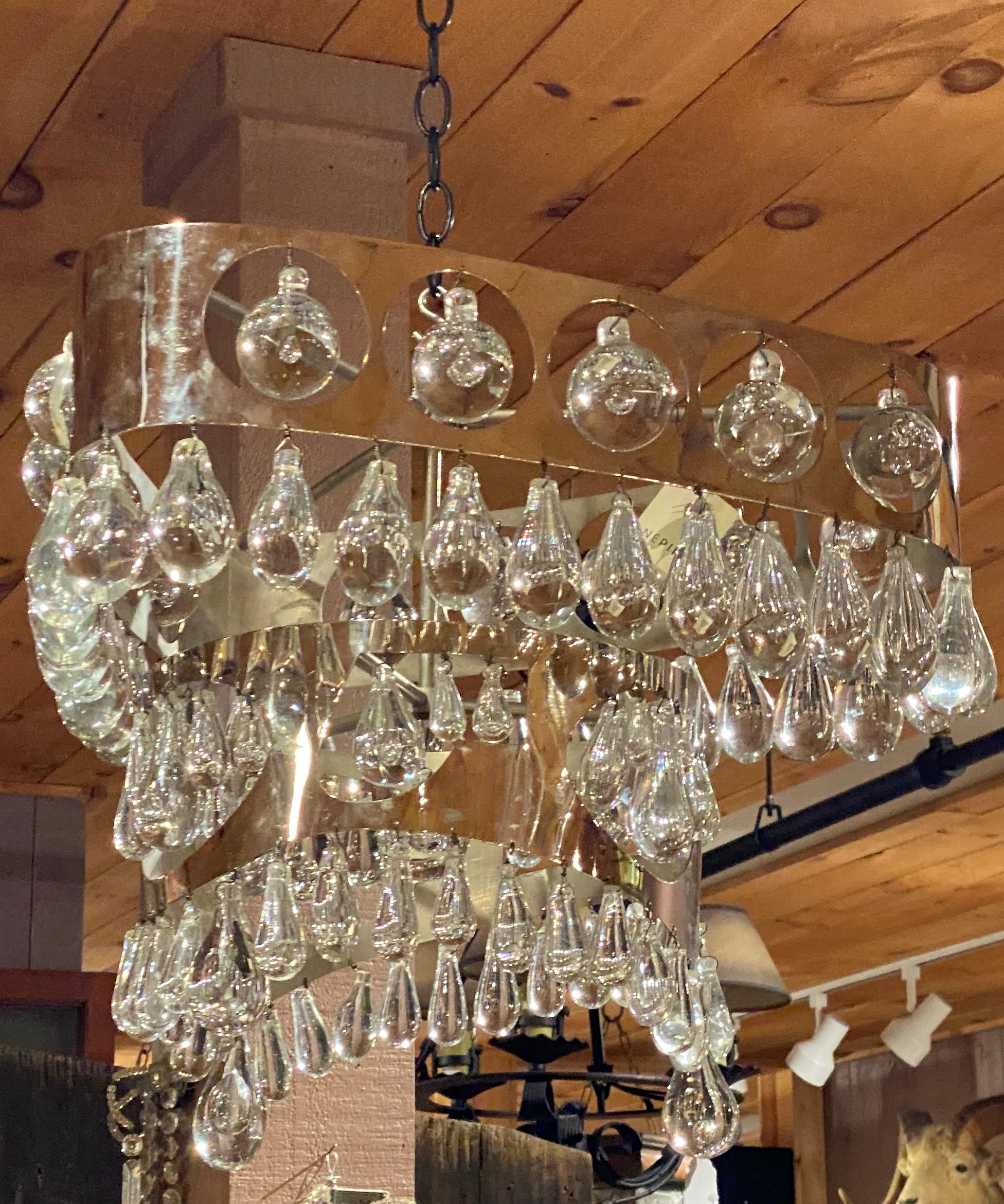 A fine mid-20th century designer chrome and crystal two-tier chandelier by Nepir Portugal in the Art Deco style with triangle top tier and round lower tier, each adorned with solid round bubble glass pendants, as well as smaller teardrop pendants.