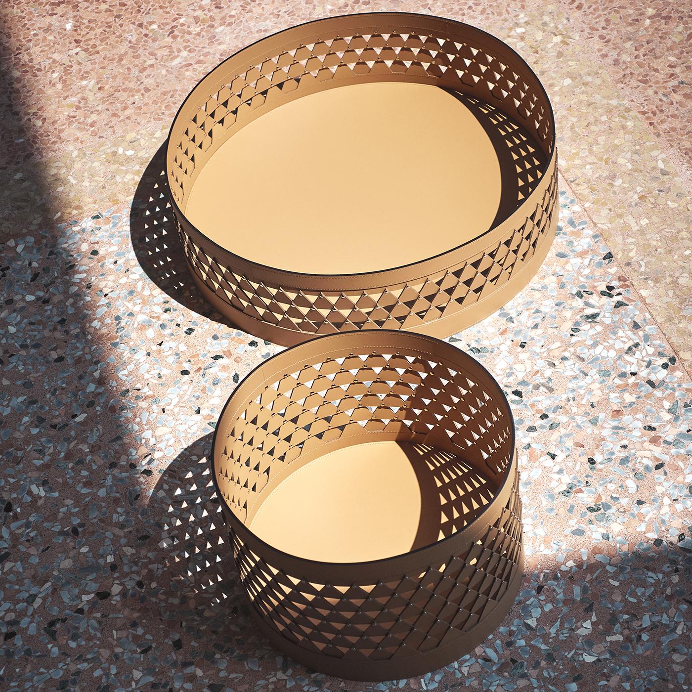 Nereide 70 round brown leather basket by STUDIOPEPE features an intricate diamond-weave structure that plays with light and shadow throughout the day. This medium-sized object brings a quiet elegance to any setting, balancing delicate craftsmanship
