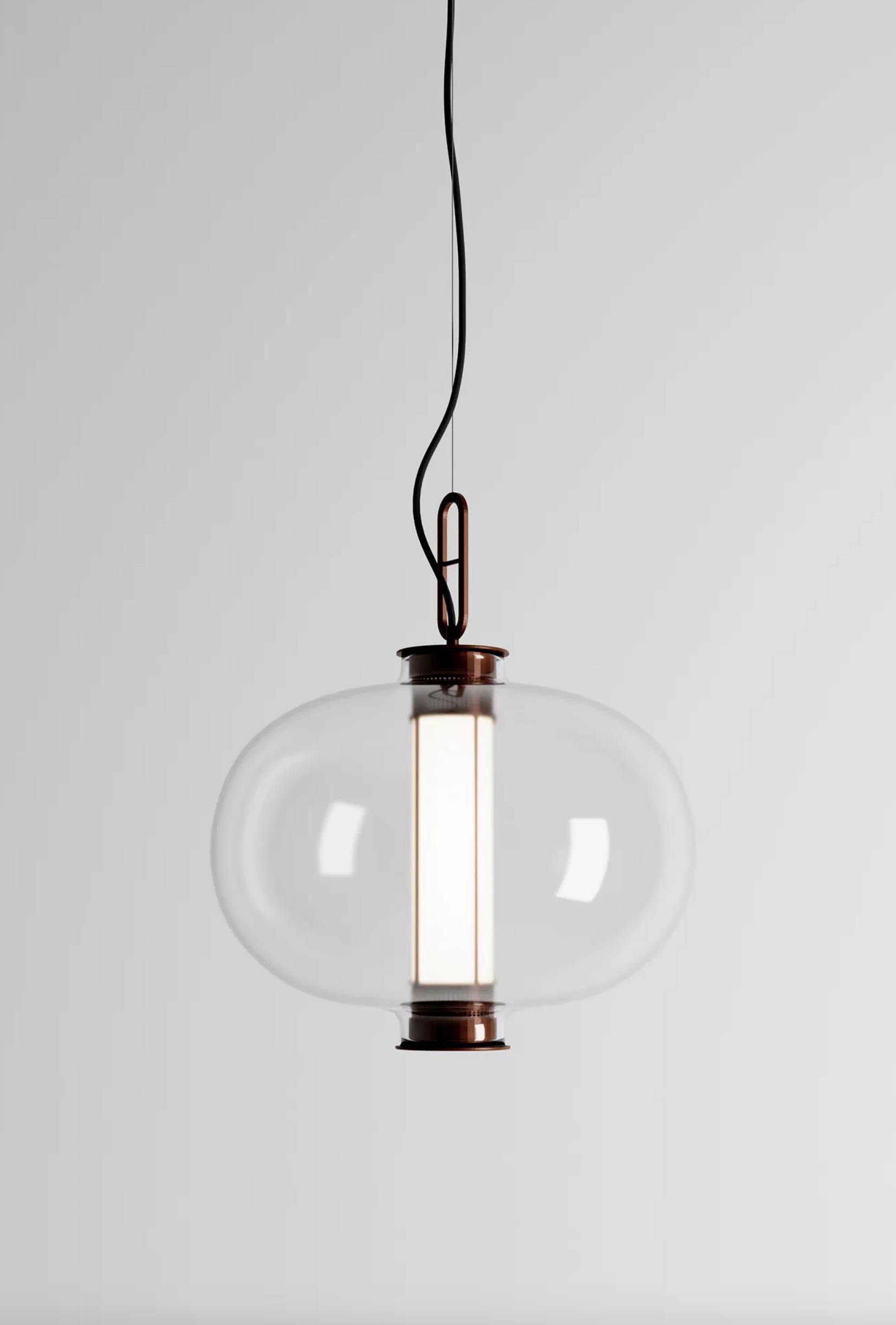 Neri & Hu Bai T Ba Ba Bronzo - Lampada a Sospensione con Diffusore in Vetro Ambrato Per Parachilna 

Questa collezione si ispira alle tradizionali lanterne cinesi. Questa versione, tuttavia, è molto sofisticata. Realizzato con una struttura