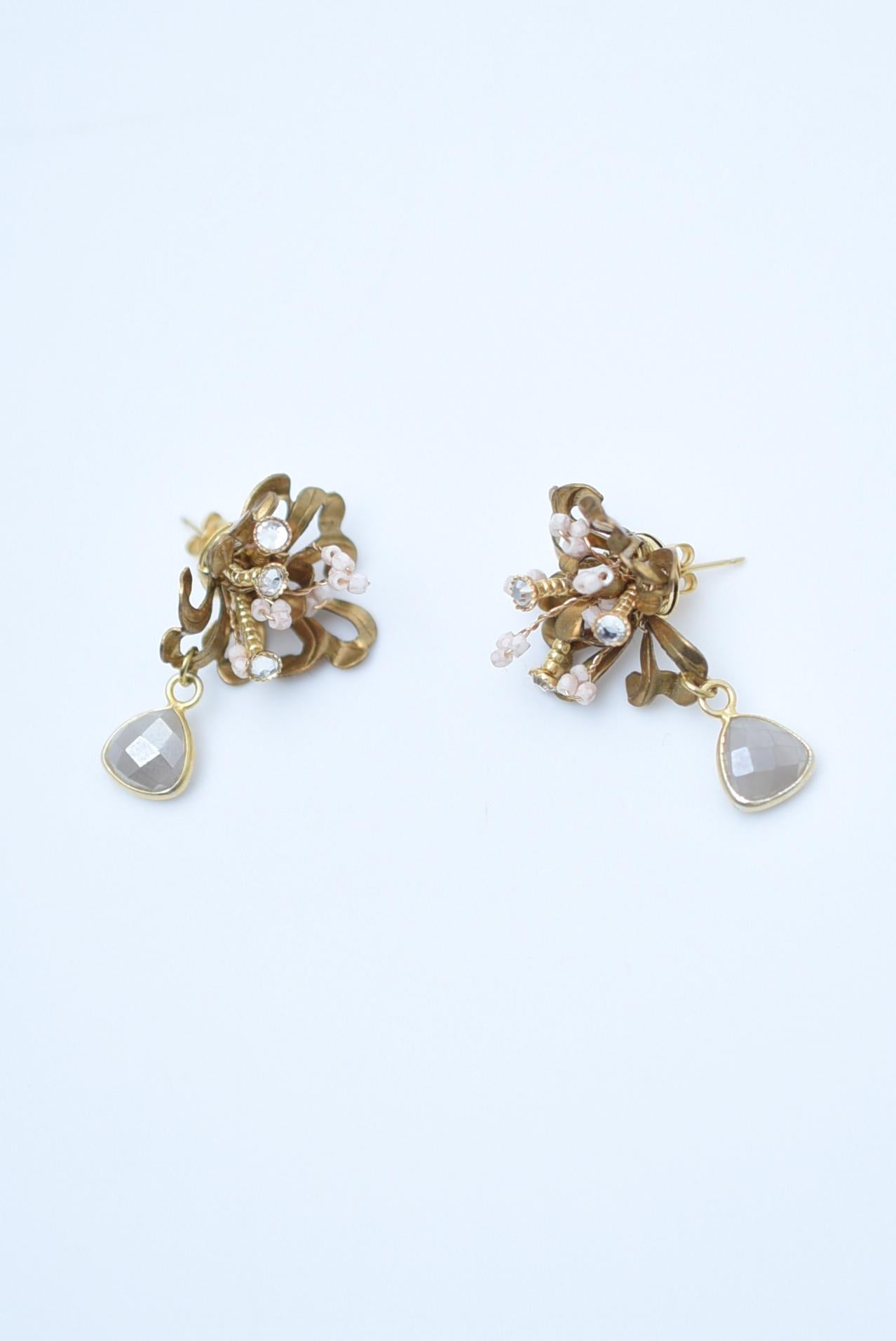 material:Brass, Vintage 1970s Japanese glass pearls,swarovski,1970s vintage parts
size:length 3cm


The key feature is the grey moonstone that swings under the nerine flower. The larger flower motif and the pale pink beads in places make these