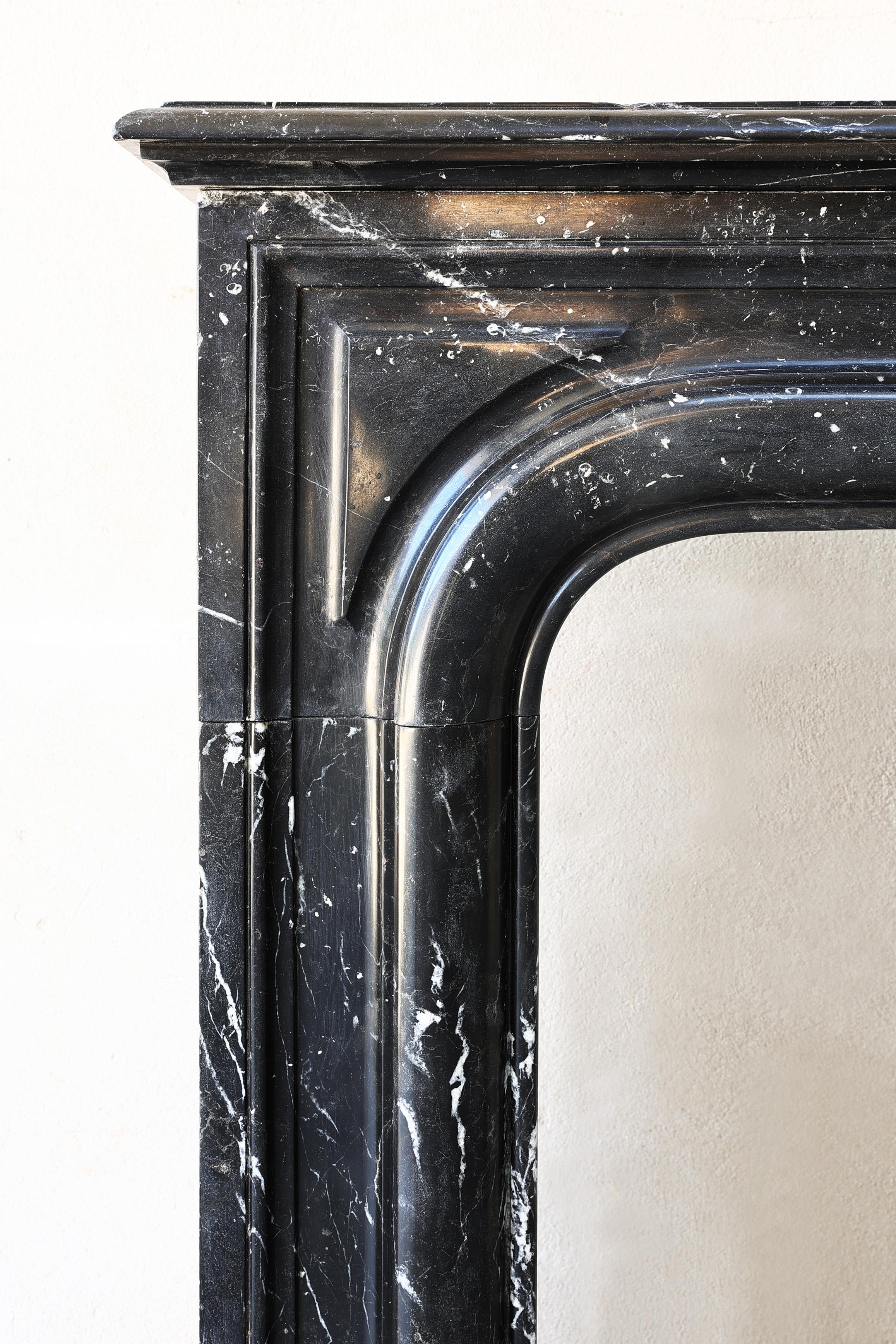 Beautiful antique fireplace from the 19th century made of Nero Marquina marble! This mantelpiece has a chic appearance and is in the style of Louis XIV. This mantelpiece has a warm and rustic appearance and fits into a modern or classic interior.
