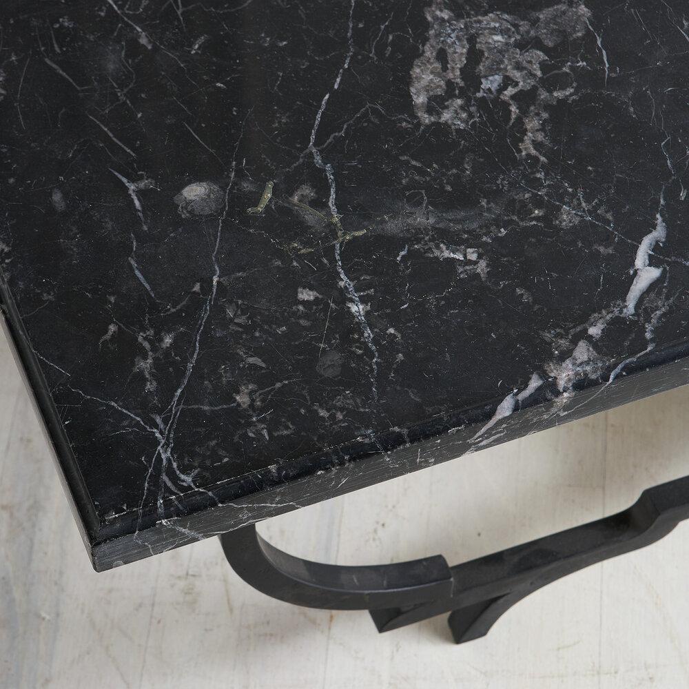 A sculptural coffee table in polished Nero Marquina marble and a black metal base. Featuring a lower floating shelf and an elegant and interesting frame.

Dimensions: 53.5