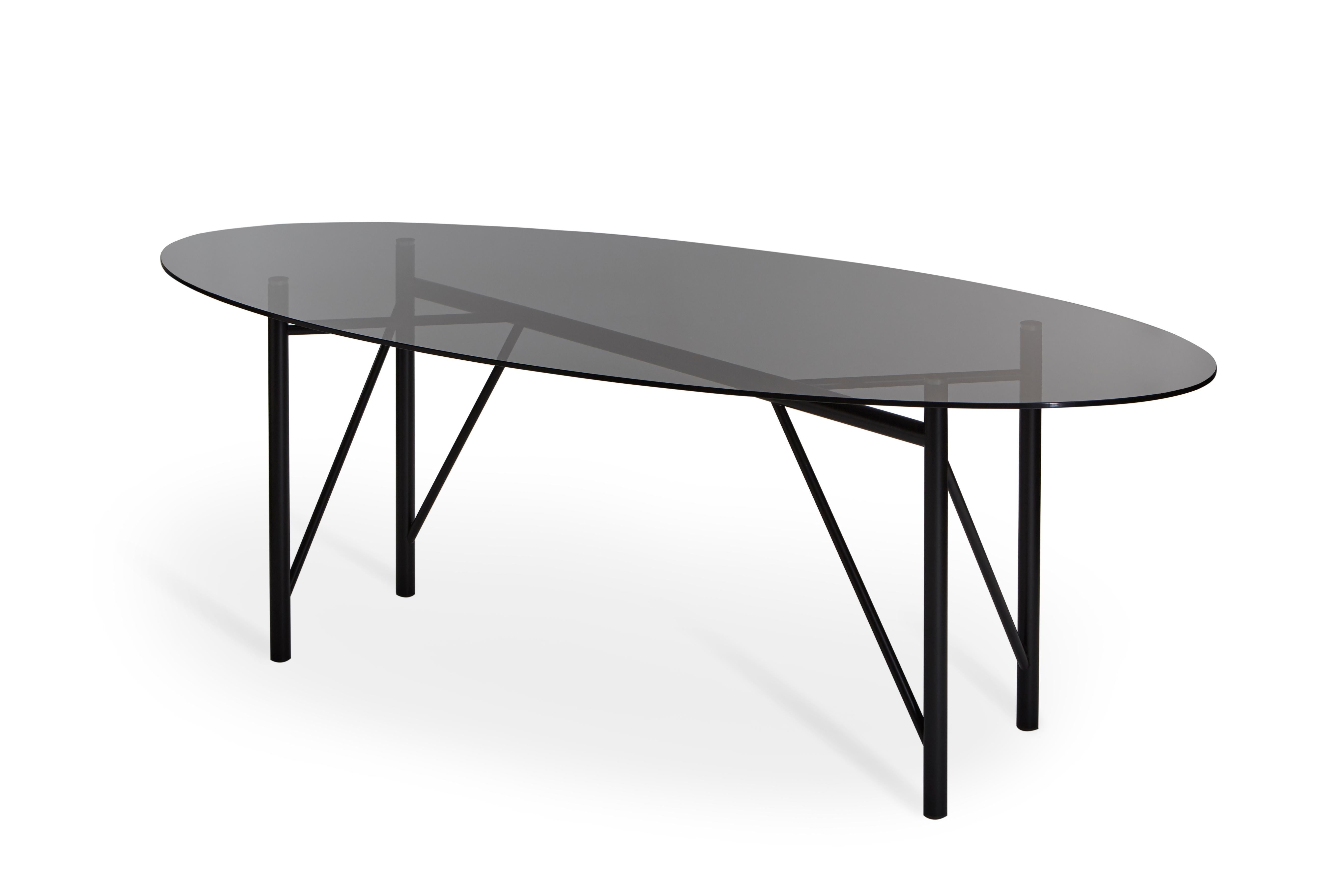 Nero Table tubulaire ovale de Mentemano
Dimensions : L220 x P 100 x H 75 cm
Matériaux : Base noire, dessus gris fumé

Le projet est basé sur la légèreté et l'attention portée aux détails. Les volumes et les lignes sont le résultat d'un processus