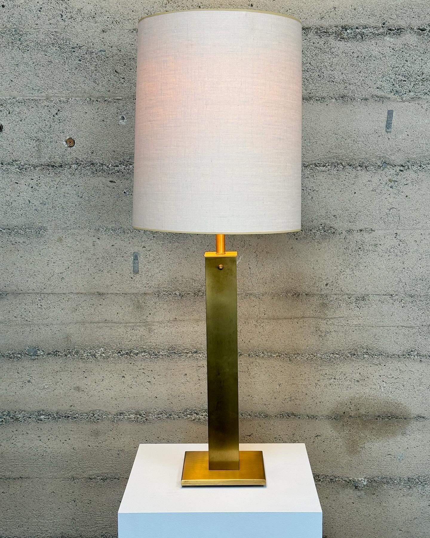 1960s Nessen Studios tall table lamp designed by Greta Von Nessen, constructed of brass, linen and glass. The body of the lamp is a tall square column with a square base, towards the top end is a rotary switch, a tubular stem and a glass diffuser