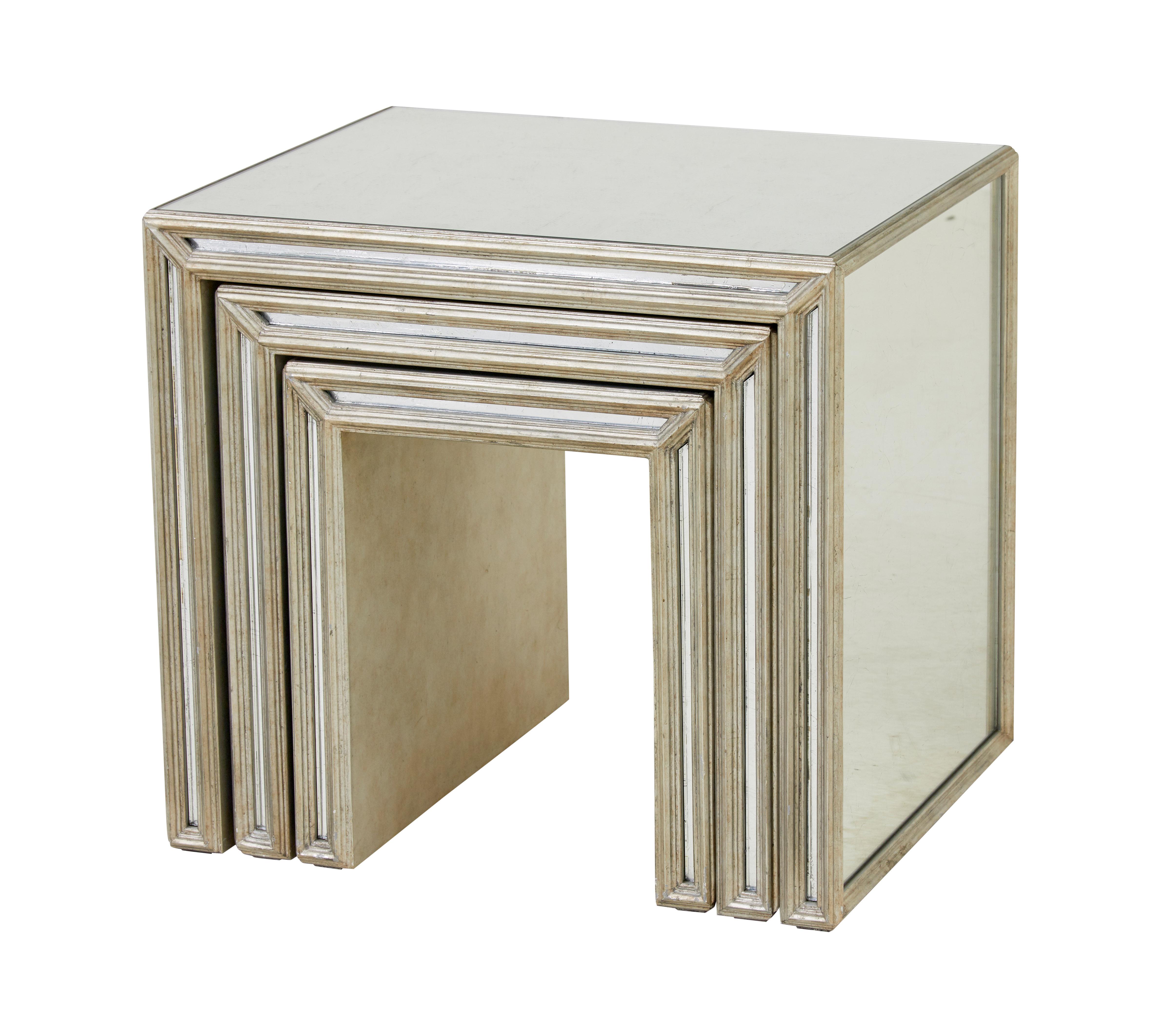 Modern mirrored nest of tables.

Mirrored tops and sides with silver painted moulded wood work.  Mirrored front edge slip inbetween the moulding.

Some minor marks to woodwork and wear to surfaces.

Smallest table measurements:
Height: 17