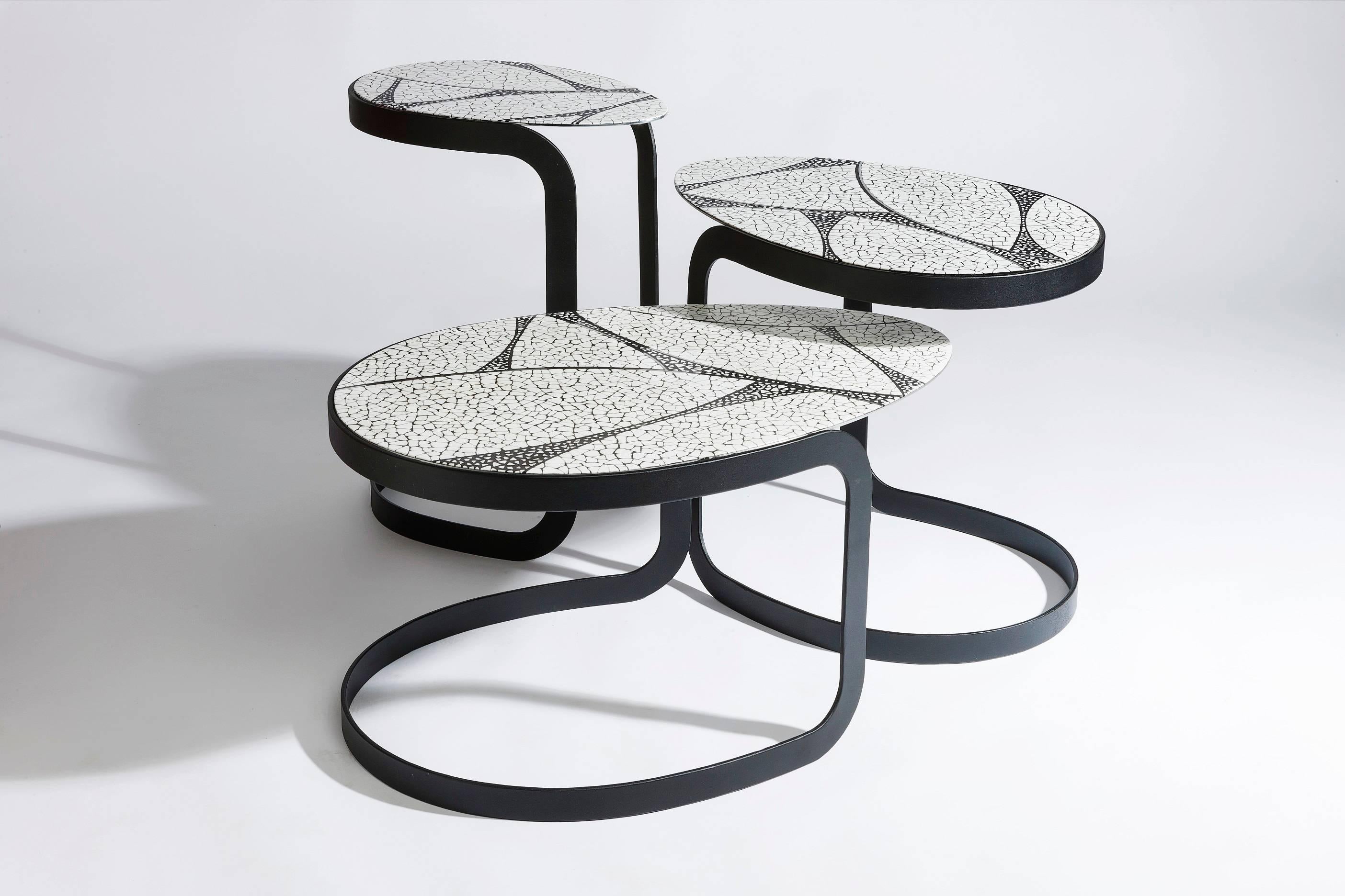 Nest of Egg tables, their tops covered in a veneer of ostrich eggshell sits on a steel base in a black sandpaper finish, sold individually or as a set. Price and details shown are for the smallest in the set, which is also the tallest. Tables have