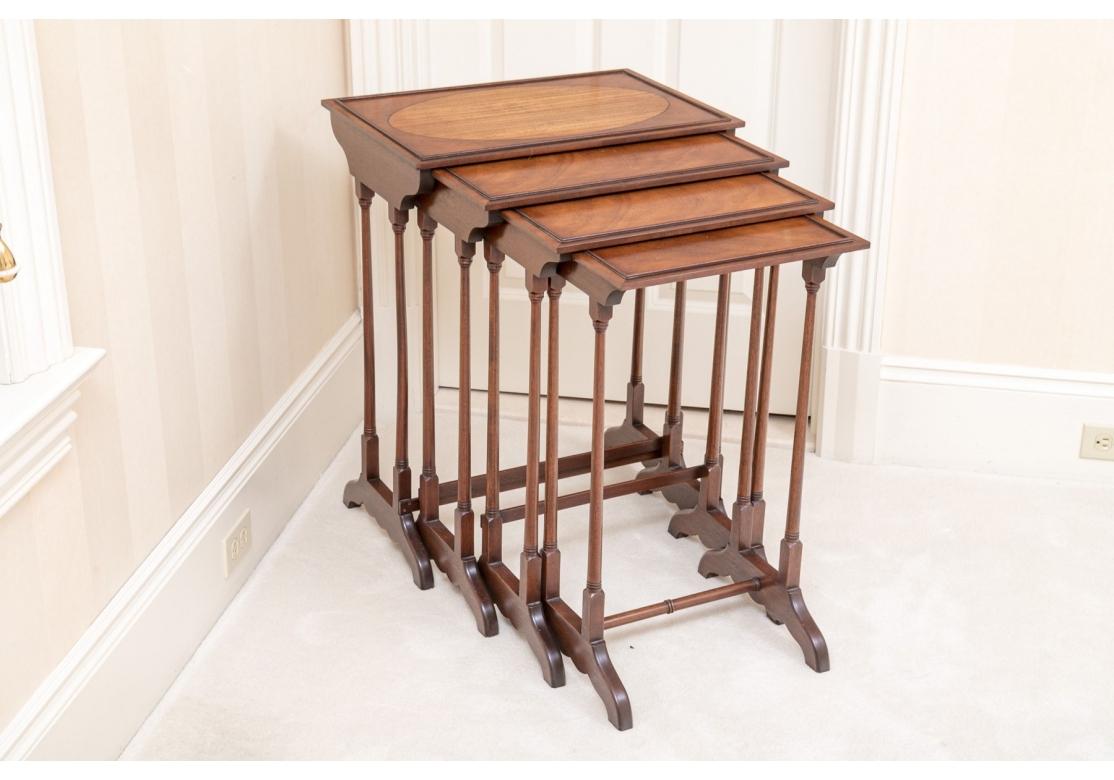 Un élégant nid de quatre tables empilables de style Regency. Les plateaux de table ont des moulures extérieures en relief et le plus grand présente un beau médaillon central ovale surdimensionné dans un bois plus clair.  Les côtés façonnés reposent