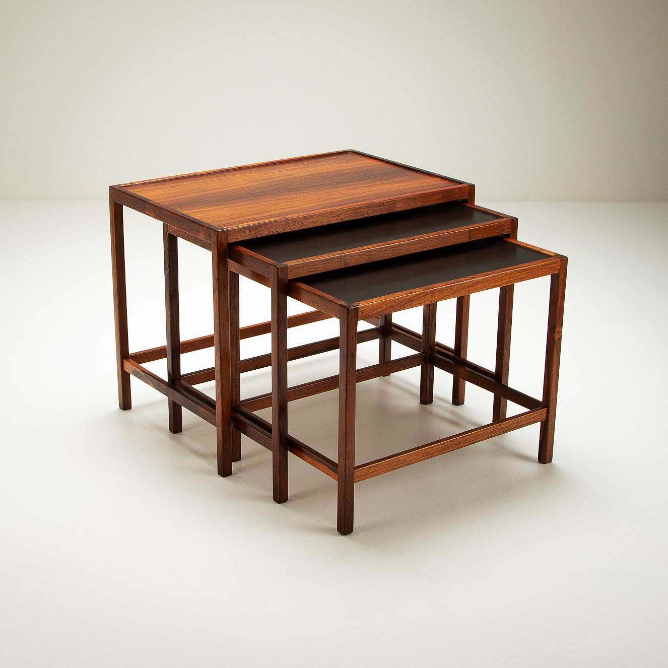 A set of 3 Brazilian rosewood nesting tables designed by Kurt Østervig for Jason Møbler, Denmark, 1960s. Top table in rosewood. Tables 2 and 3 in rosewood with black formica tops. Beautifully crafted and in excellent condition.

   