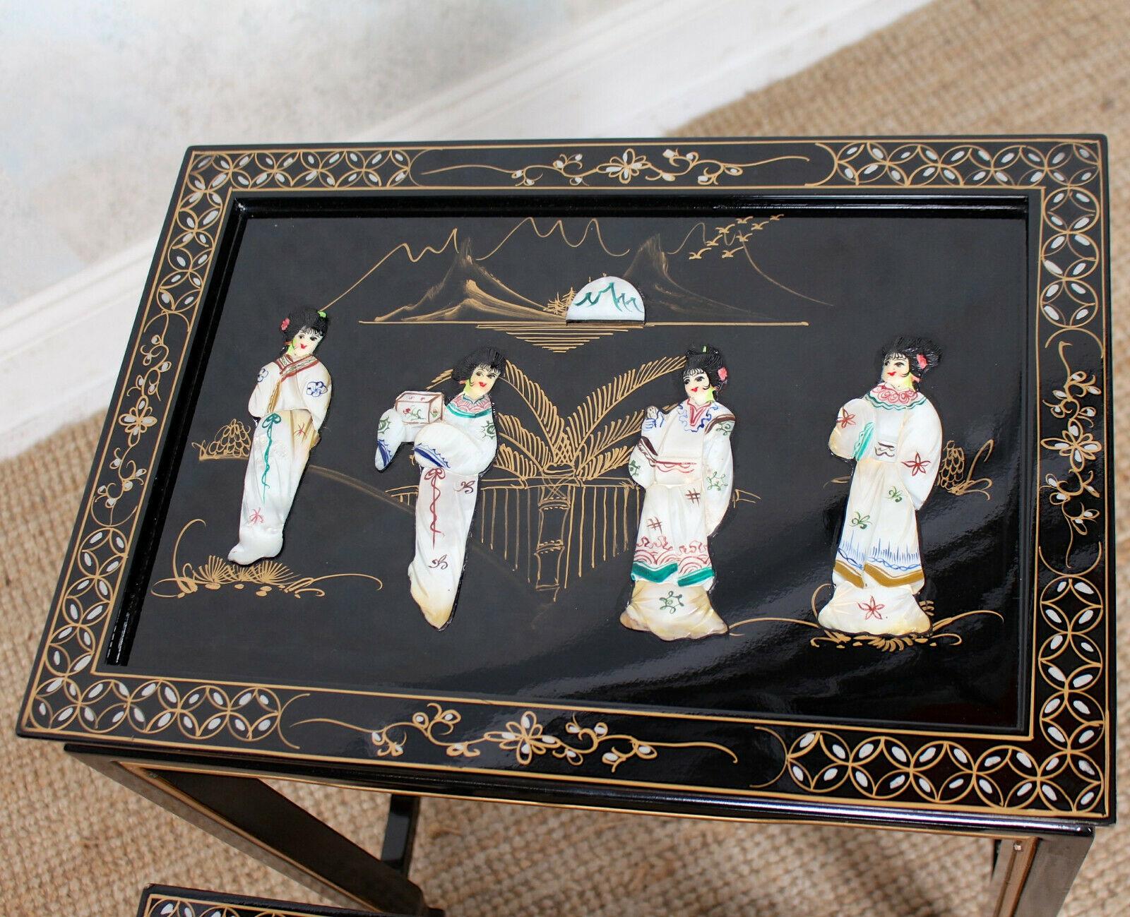 An impressive Oriental nest of three tables.

Ebonised with gilt inlay and lacquered finish chinoiserie and inlaid with gilt borders. Each table top with glass tops enclosed Japanese garden scenes of Geishas.