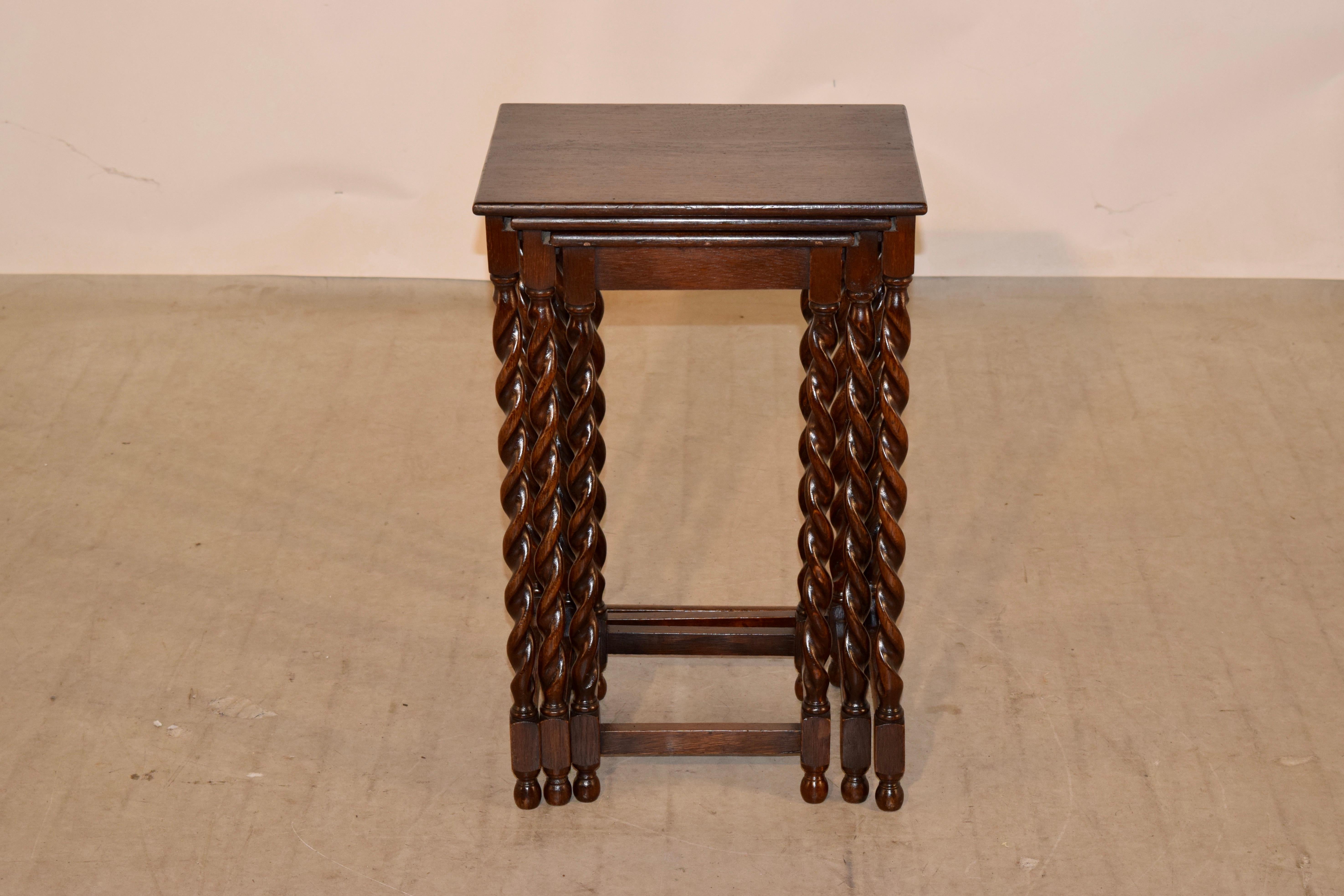Set of three oak nesting tables from England, circa 1900. The tops have simple lines and are supported on hand turned barley twist legs, joined by simple stretchers. The largest table measures 15.5 W x 12.88 D x 24 H, the medium table measures 13 W