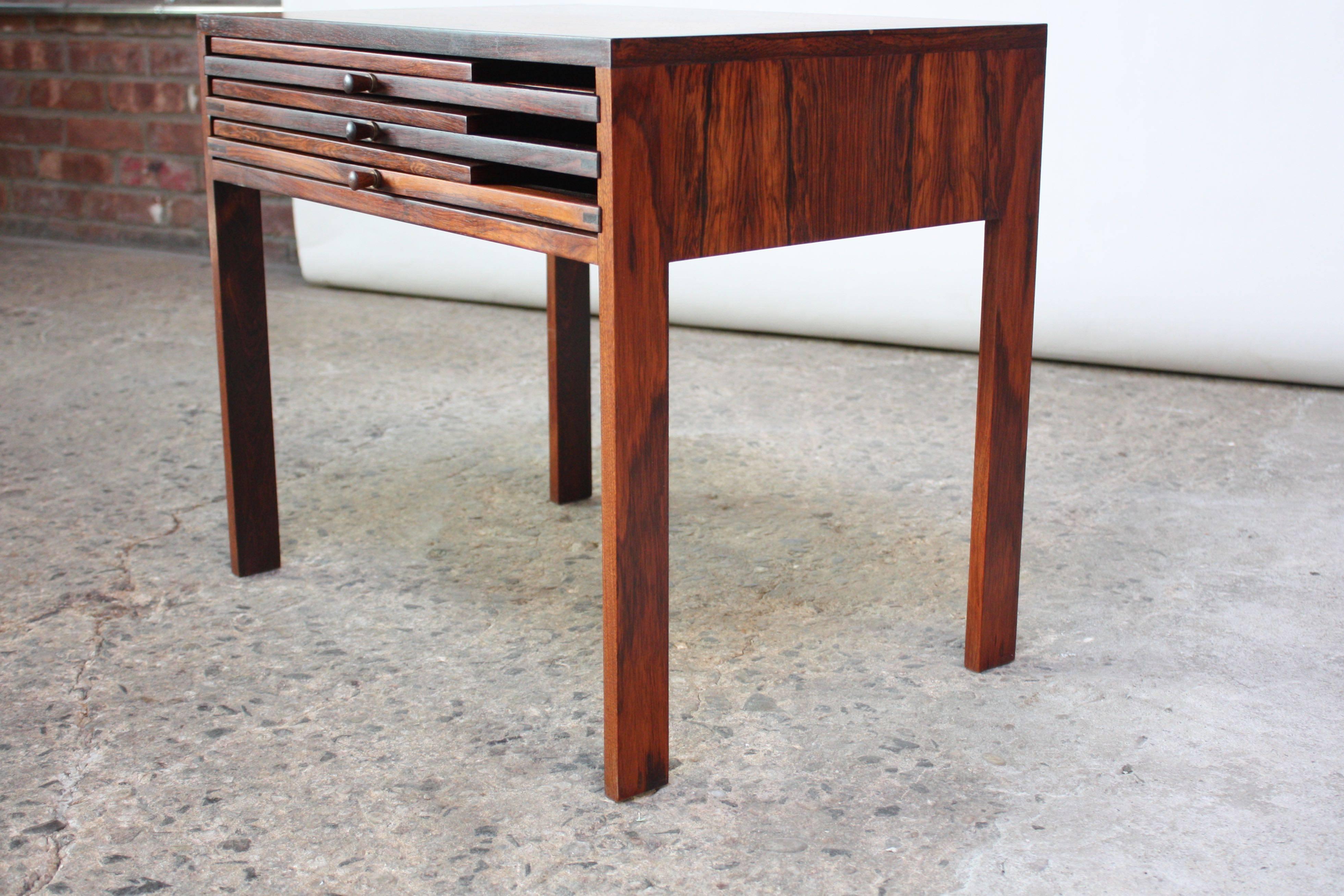 Complete set of three rosewood folding tables that nest into an occasional table for storage by Illum Wikkelsø for CFC Silkeborg. Details include sculptural rosewood pulls and solid brass accents / hinges. 
Each folding table measures: W 16.5