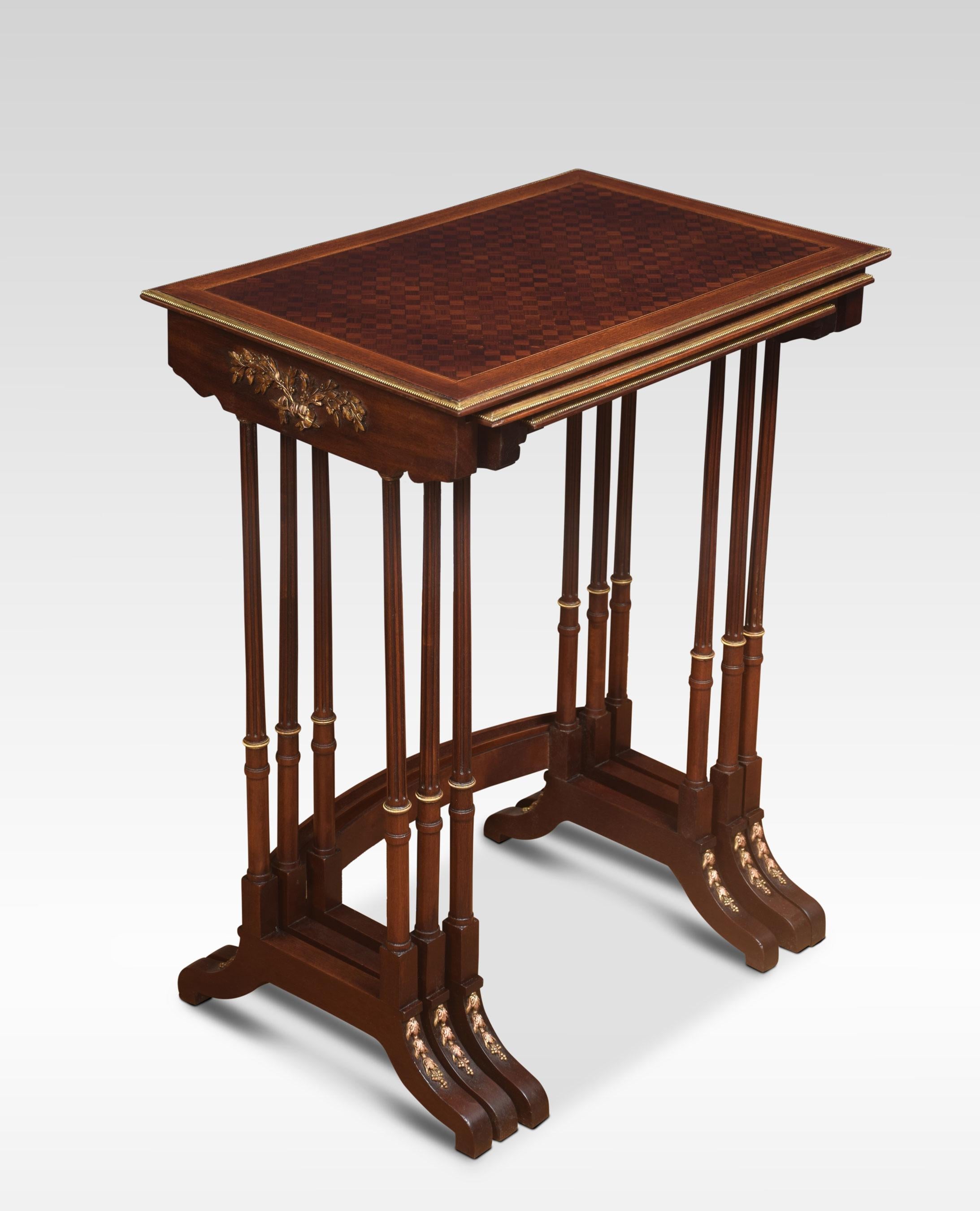 Nest of three walnut tables, the rectangular parquetry tops enclosed by a brass banded edge. raised on slender turned tapered supports with brass mounts, united by stretcher. All raised up on short swept splayed supports.
Dimensions
Height 28