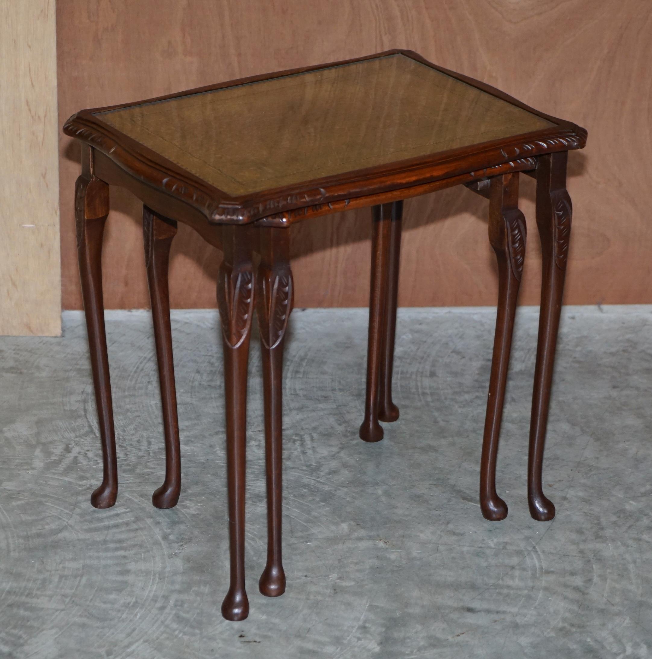 We are delighted to offer for sale this nice green leather nested table 

A good looking little nest, the legs have a mahogany finish with ornate carvings, the tops are green leather with gold leaf embossing and glass tops

Condition wise we