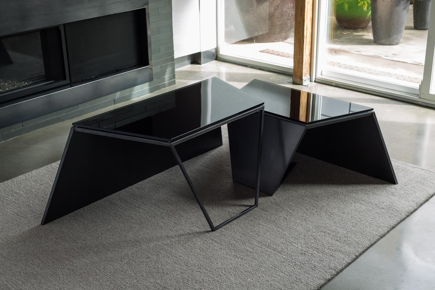 Fold Coffee Tables are a signature example of Force/Collide modern geometric, minimal and modular style. Finely constructed and finished with blackened steel and smoked gray glass, they're a study in manipulating the triangular form into dimensional