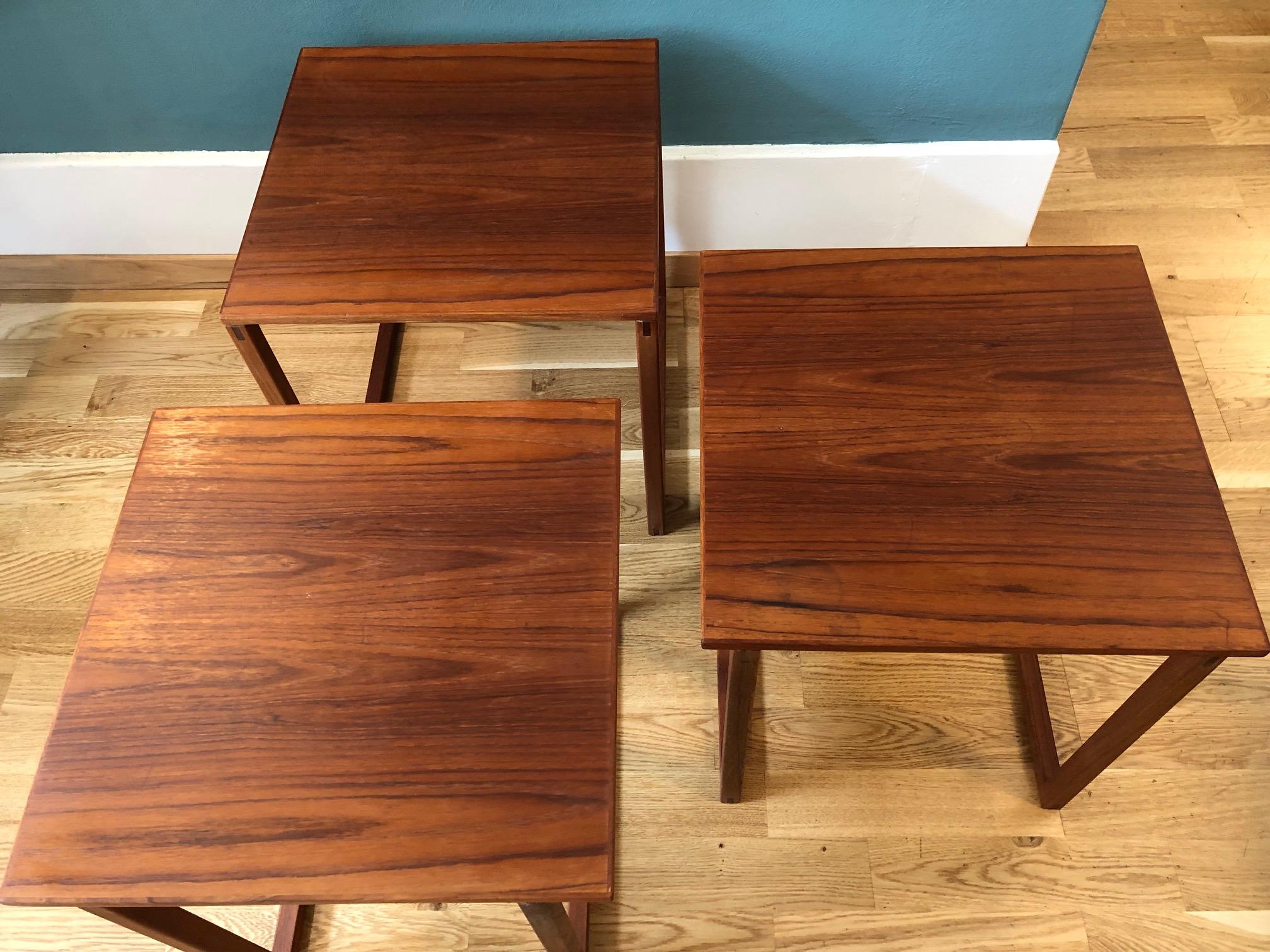 Set of 3 interlocking teak nesting side tables which can be placed individually into each other or loose. You can also form an open side and bottom cube. Two tables slide into the sides of the center table. Constructed of figured teak wood veneered