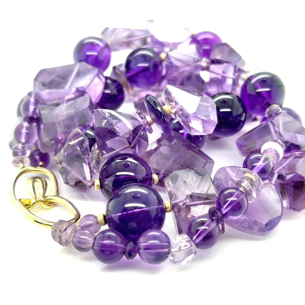 Questa audace collana è caratterizzata da due fili di perle di ametista di forma rotonda e sfaccettata! Le perle di cristallo a forma libera mostrano bellissime sfumature di colore viola tenue e variano in dimensioni con forme uniche, mentre i tondi