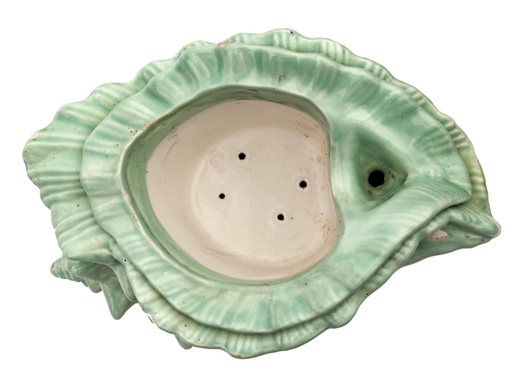 Glazed ceramic conch shell planter with self-draining interior pot.
Muted green surface inner planter in ivory.
Minor negligible chips.