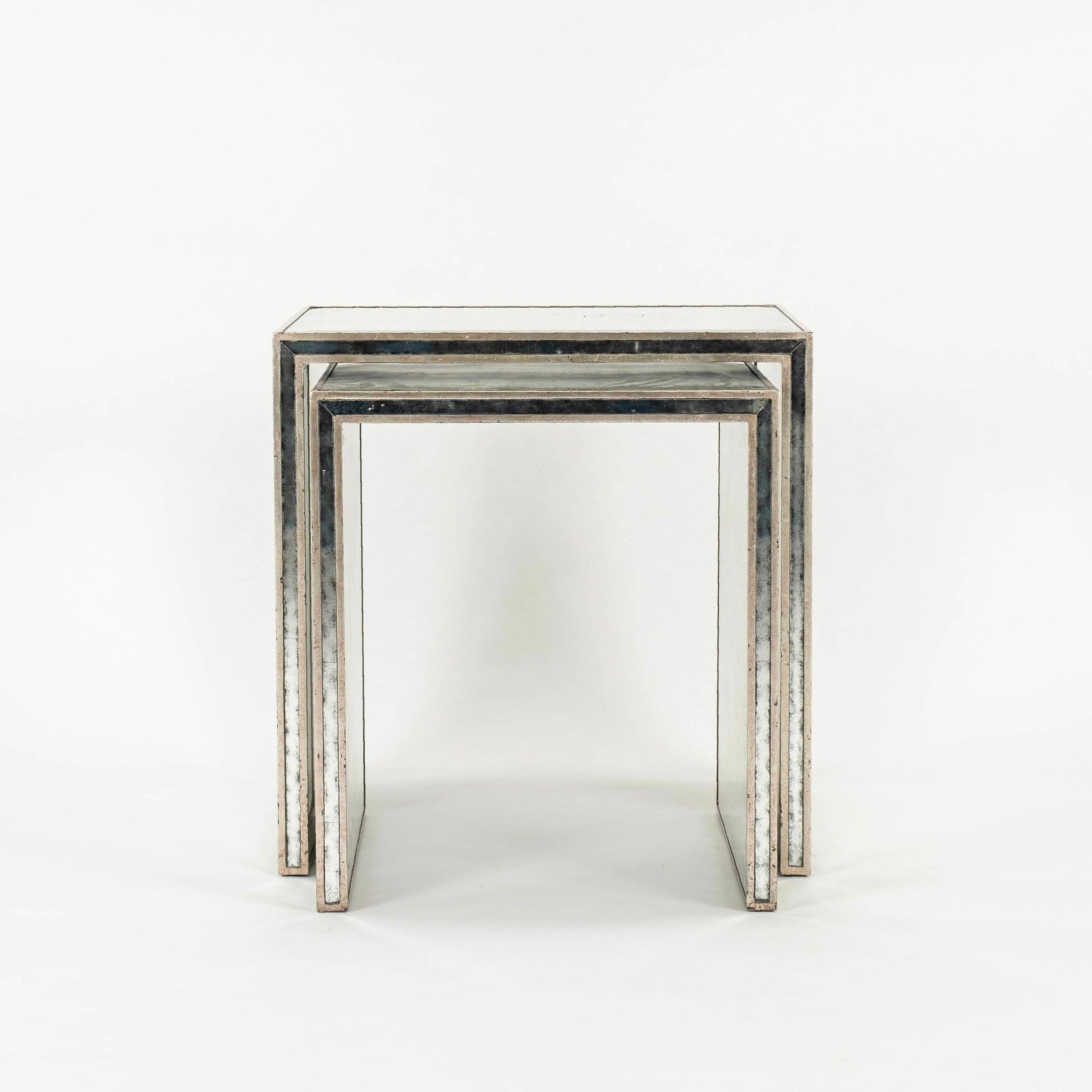 Nesting mirrored table set of two tables featuring antiqued mirror surfaces and silver gilt trim. 

Table 1: 28