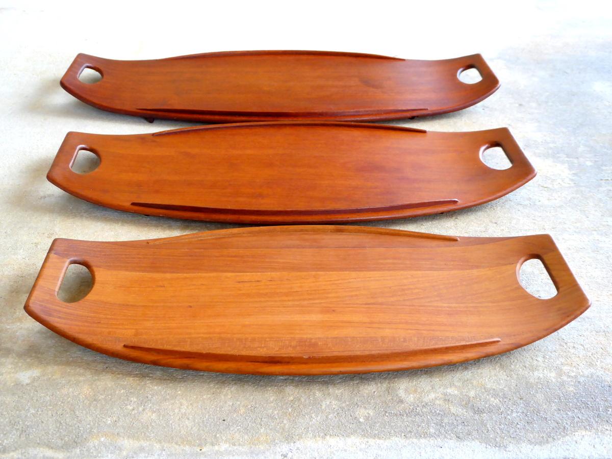 A nesting set of three staved teak serving trays. The exceptionally simple and elegant Fjord line was designed in 1956 by Jens Harald Quistgaard for Dansk. Includes the entire set of 