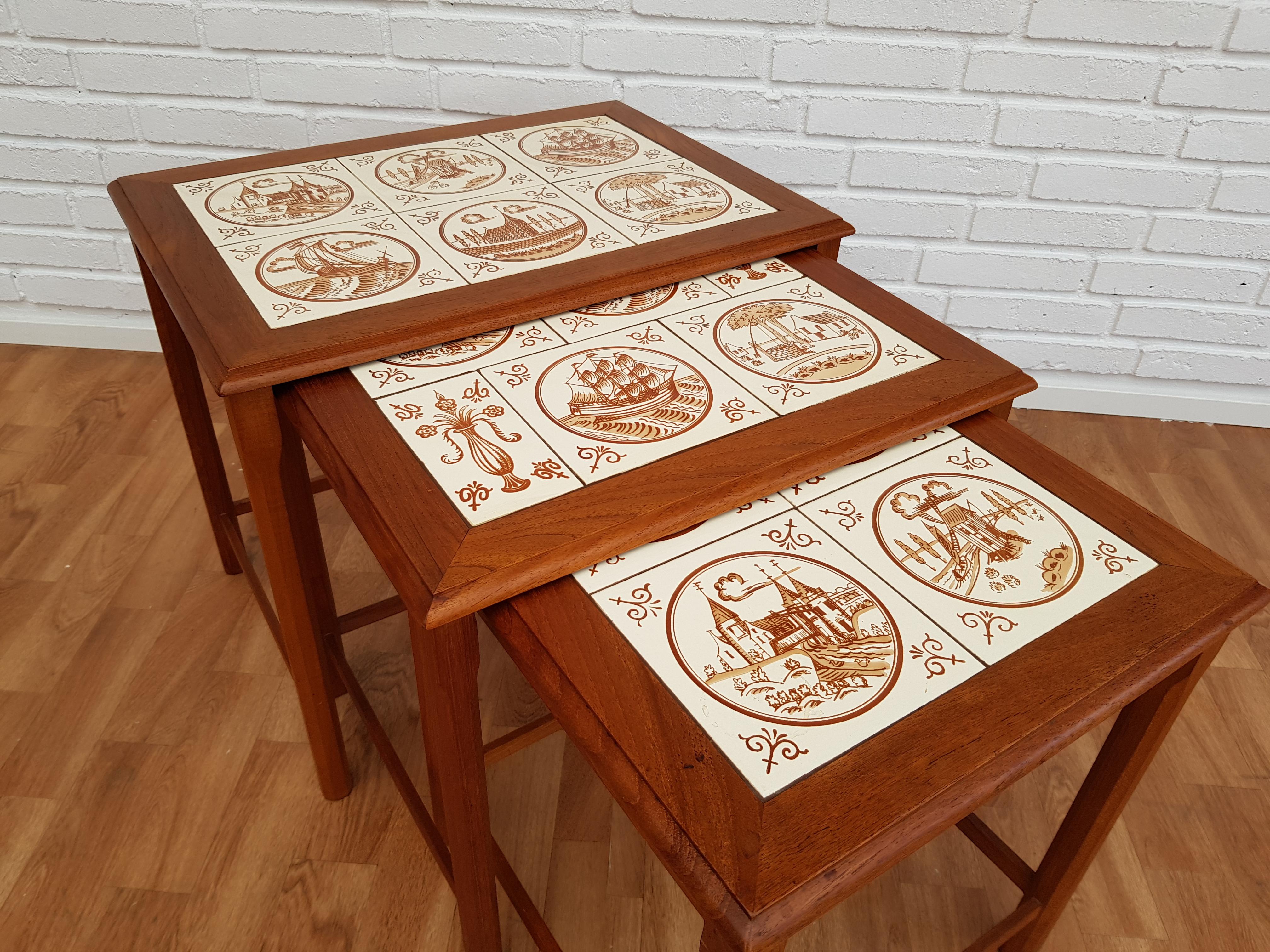 Nesting table, Danish design. Produced in about 1960 by Danish furniture manufacturer. Teak wood and hand painted ceramic tiles.