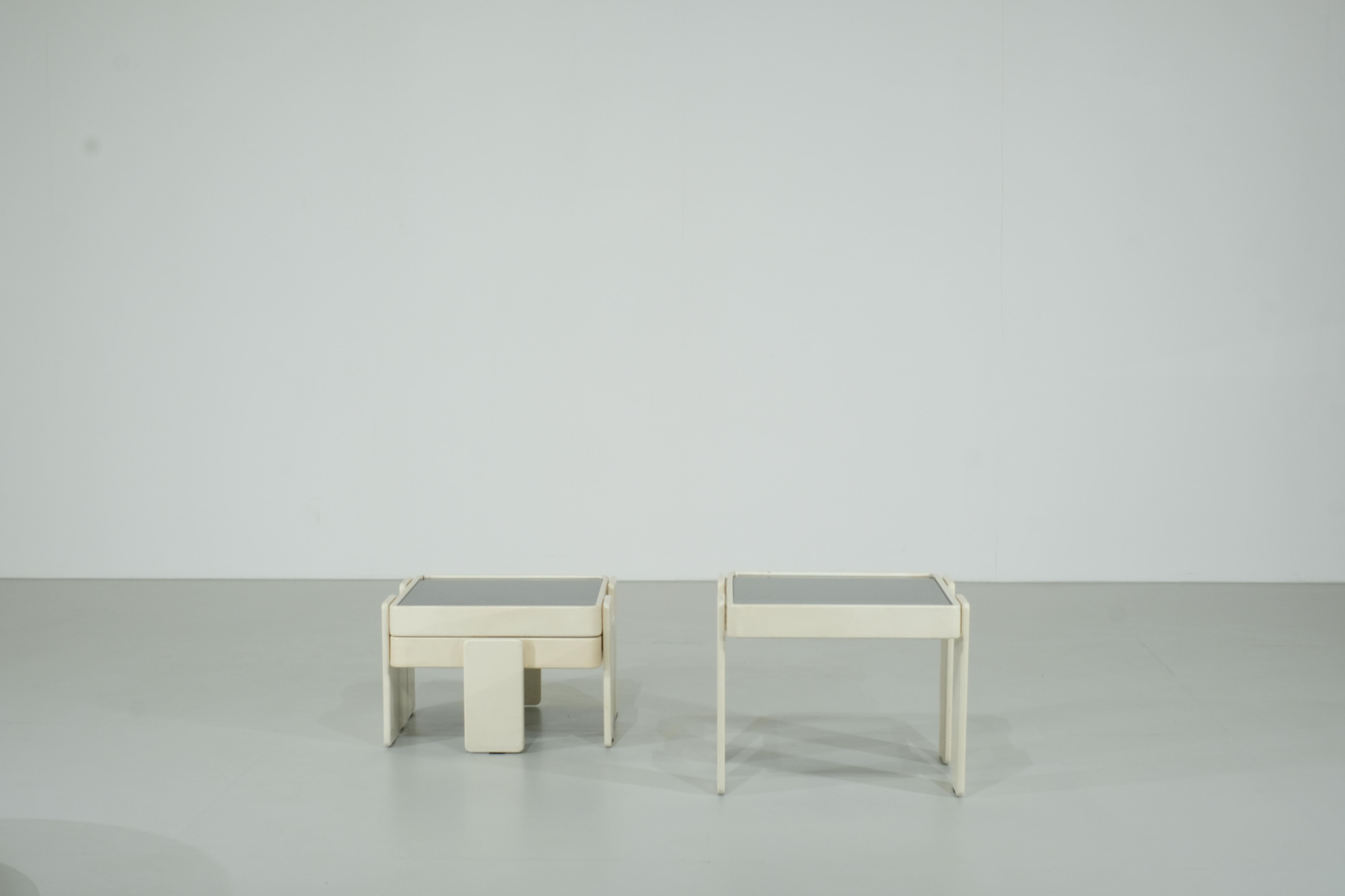 Beautiful set of nesting tables designed by Gianfranco Frattini for Cassina in the 1970s.
These tables are made of white lacquered wood and smoked glass tops.

This set is in its original condition, it is in very good vintage condition but has some