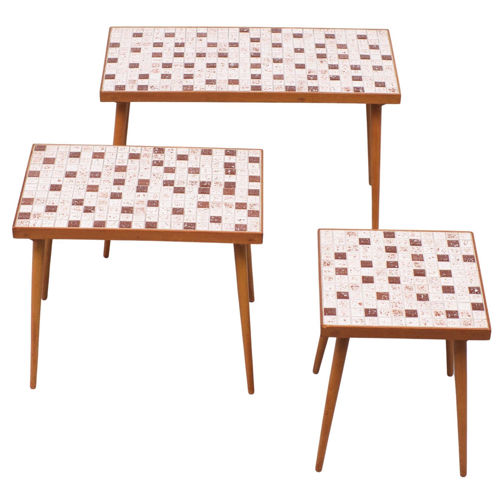 Very nice set of nesting tables, Elegant Teak feet, comes with little Ceramic Mosaic tiles.
in several shades of Brown. Very good condition.