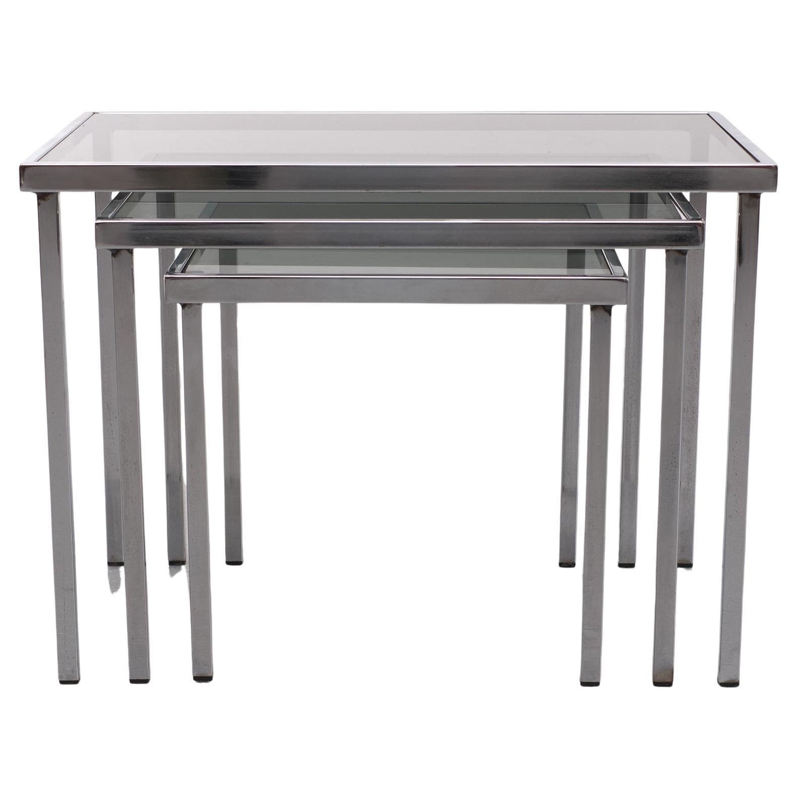 Very nice stylish set off nesting tables .Square chrome metal frame ,comes with a Grey smoked glass top ,. Still completely  original . In the style of Milo Baughman 1970s.
 L     Height 39 cm   Width  52  cm  Depth  32 cm
M     Height 34 cm  