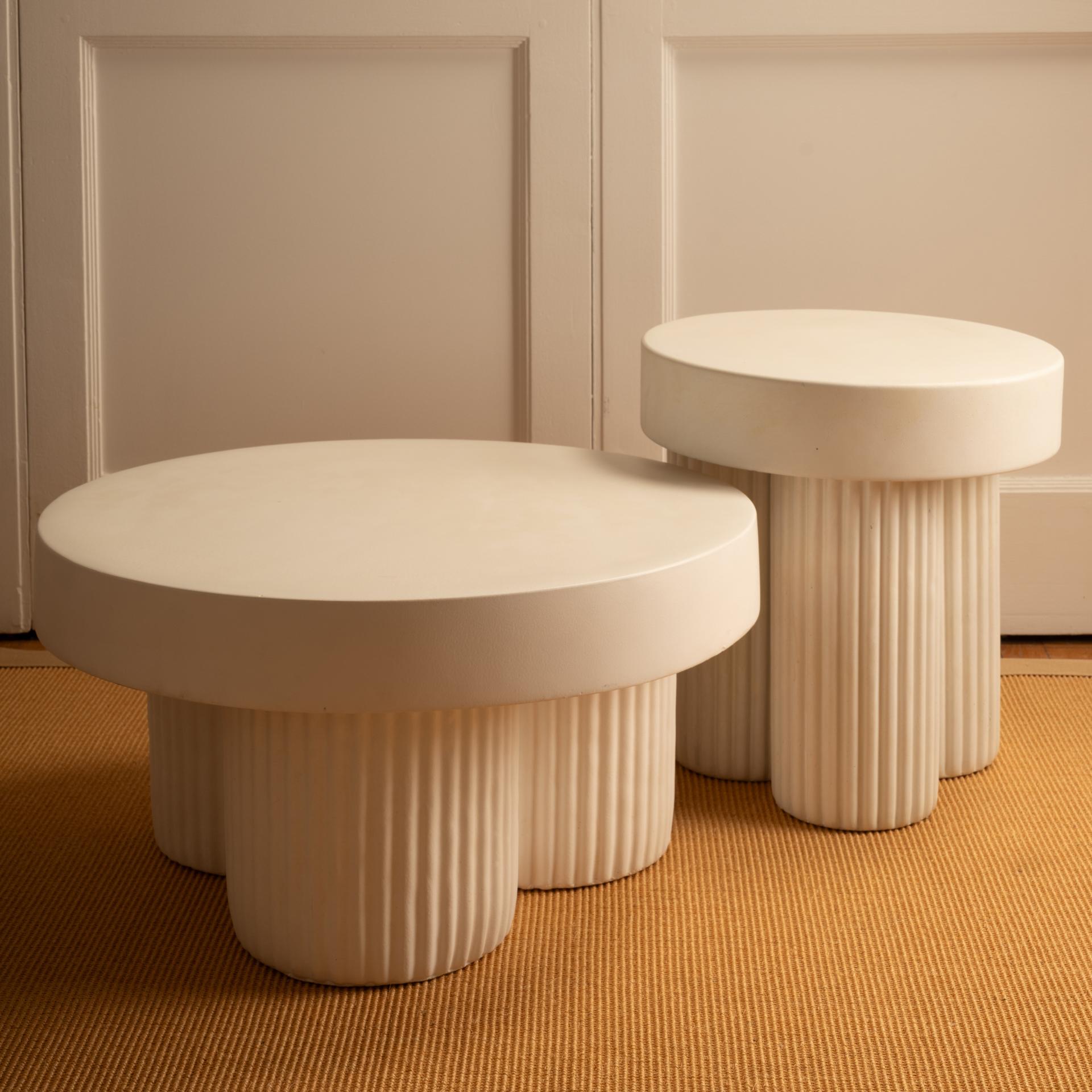 Handcrafted tables, each piece is unique. Featuring a circular top resting on three cylinder-shaped legs. The legs feature a fluted detail, adding a refined and organic signature to the design. The tables are cast in lightweight concrete with a