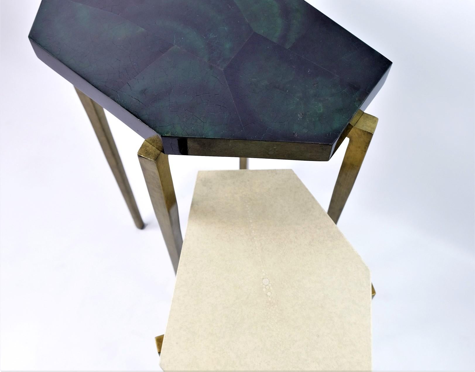 These futurist nesting tables are made of natural shagreen (Our ref ANTIC) and polished green penshell marquetry.

They have a polygonal shape top and the feet have an antique brass patina.

The tables are small and very versatile. These can be